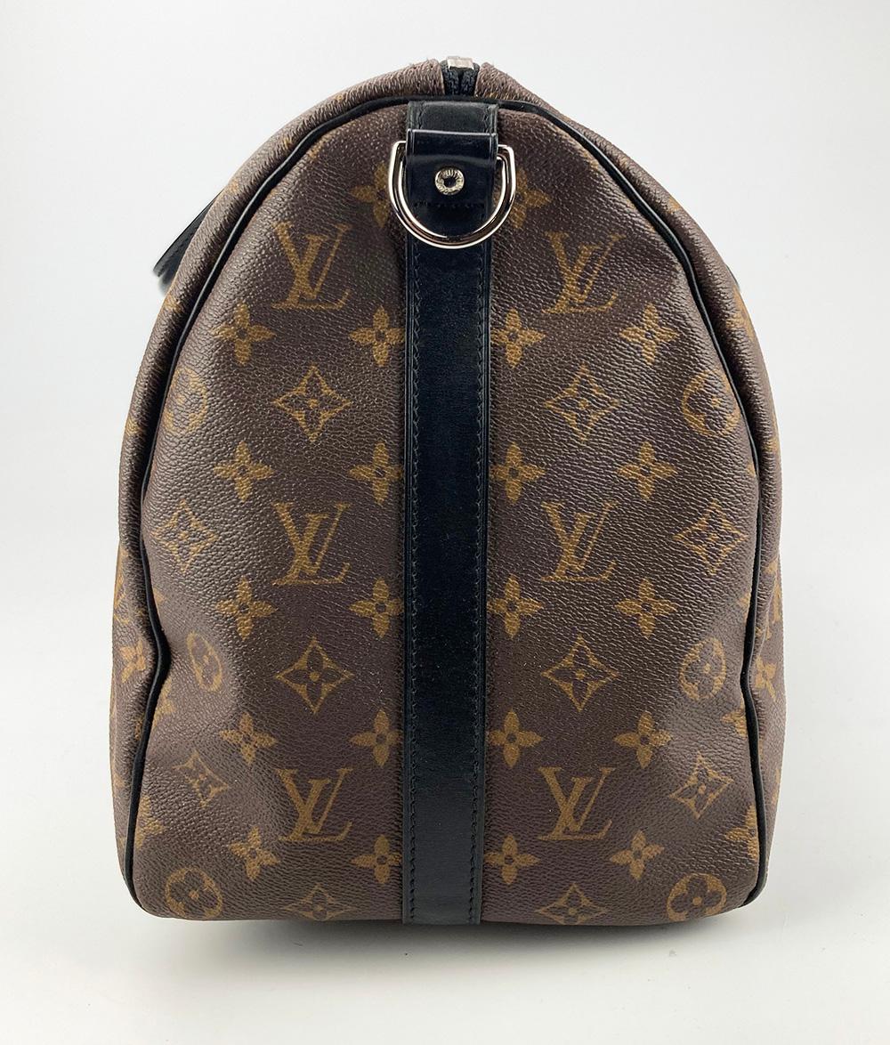 Louis Vuitton Monogram Macassar Keepall Bandoulière 45 in excellent condition. Signature monogram canvas exterior trimmed with rare black leather and silver hardware. classic 45cm size perfect for a variety of occasions. maroon canvas interior. no