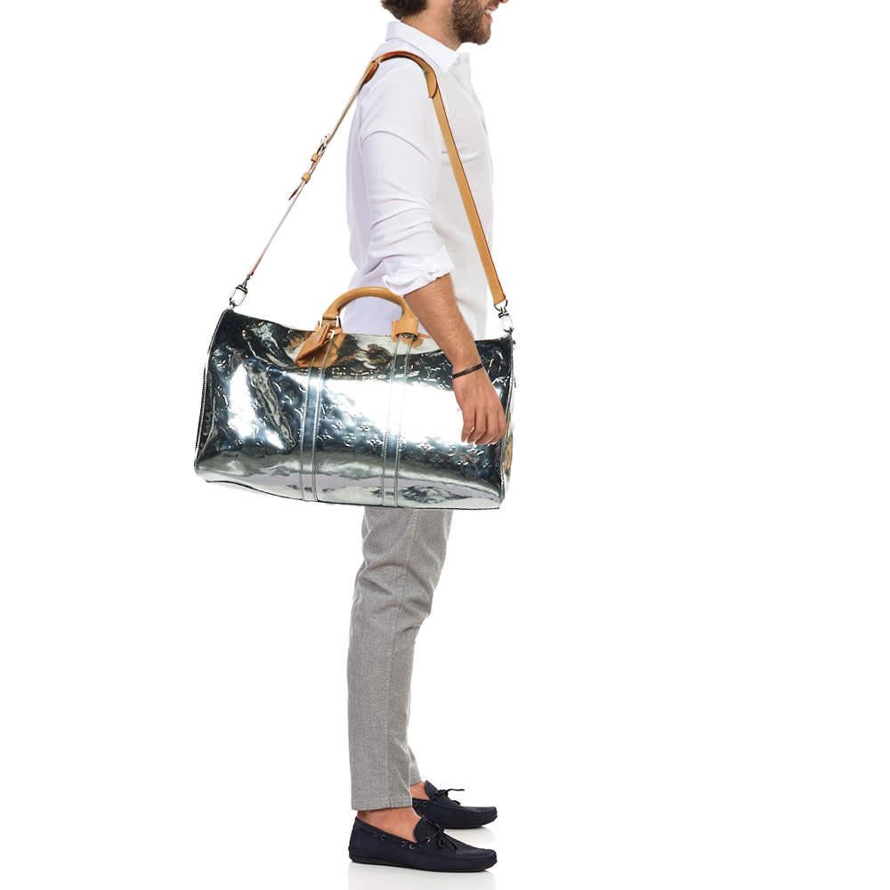 The Louis Vuitton Monogram Mirror Keepall Bandouliere 50 Bag is a striking embodiment of luxury travel. This iconic bag features the classic Louis Vuitton monogram in a reflective mirror finish  ensuring you stand out wherever you go. With its