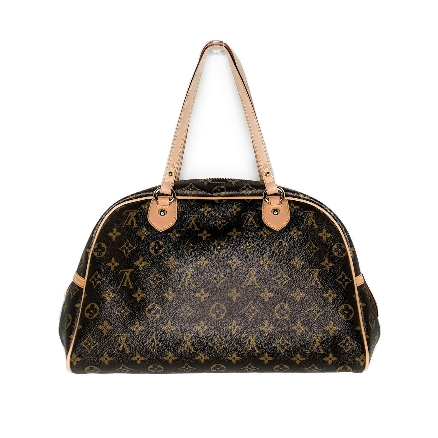 Brown and tan Monogram coated canvas Louis Vuitton Montorgueil GM with brass hardware, dual flat shoulder straps, tan Vachetta leather trim, logo placard at front, brown canvas lining, single interior slit pocket and zip closure at top. 

Designer: