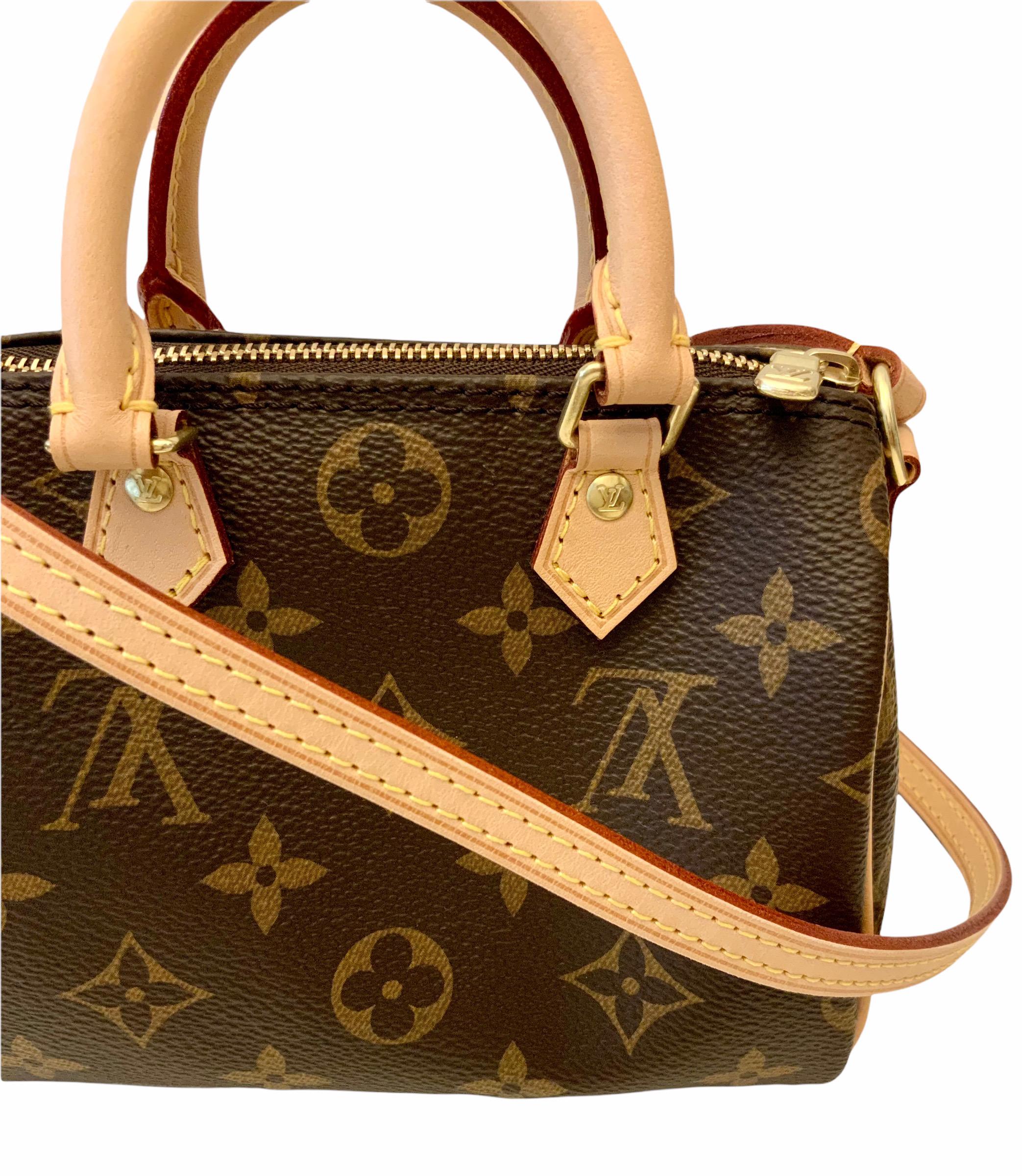 This pre-owned but new Nano Speedy is a perfect miniature version of Louis Vuitton's iconic Speedy bag. 
It is crafted from the iconic Monogram canvas with natural leather trim.
It features two handles and a non removable and non adjustable long