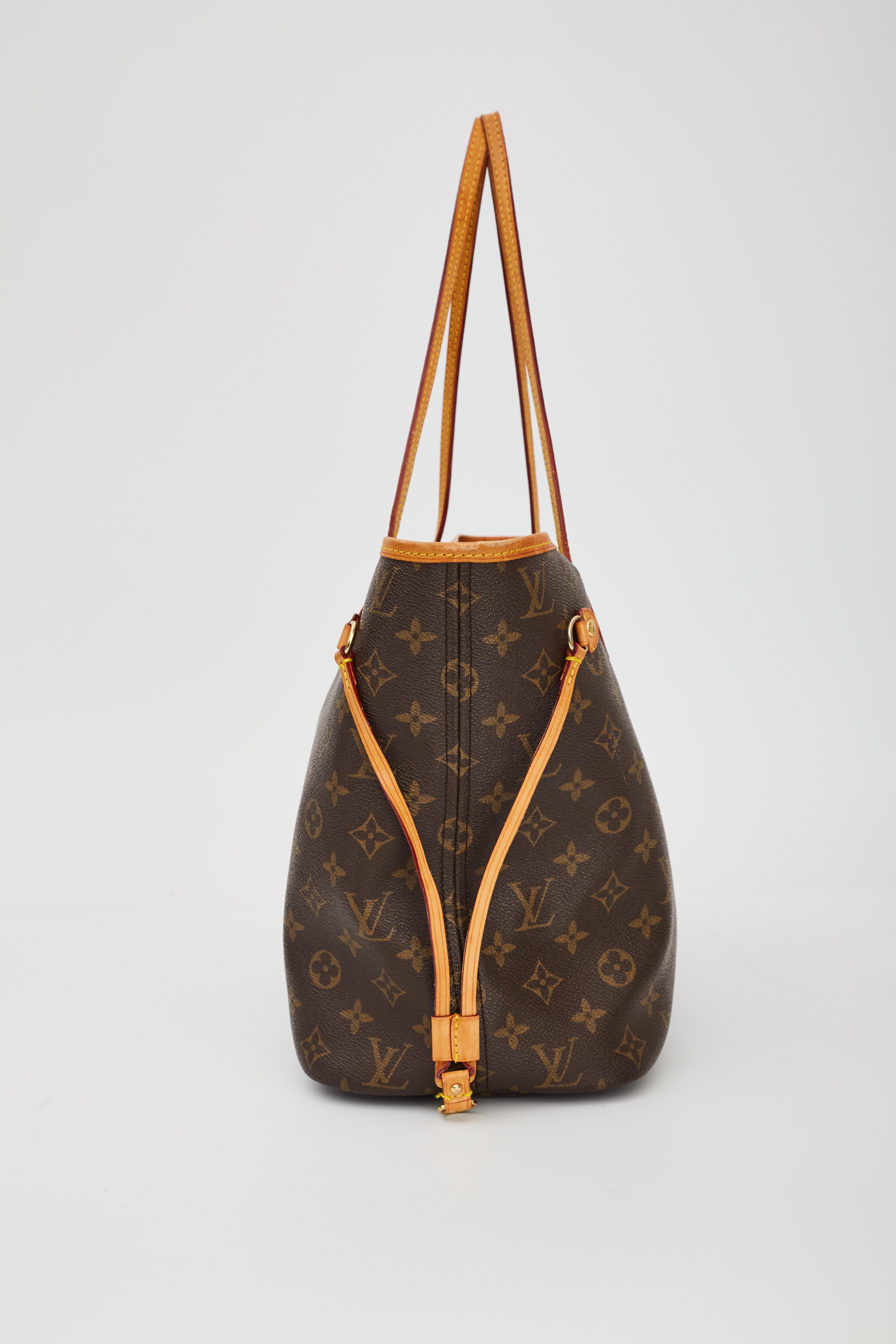 This tote is made of classic Louis Vuitton monogram coated canvas. The bag features vachetta cowhide leather shoulder straps, trim and side cinch cords, with polished brass hardware. The wide top is open to a striped beige fabric interior with a