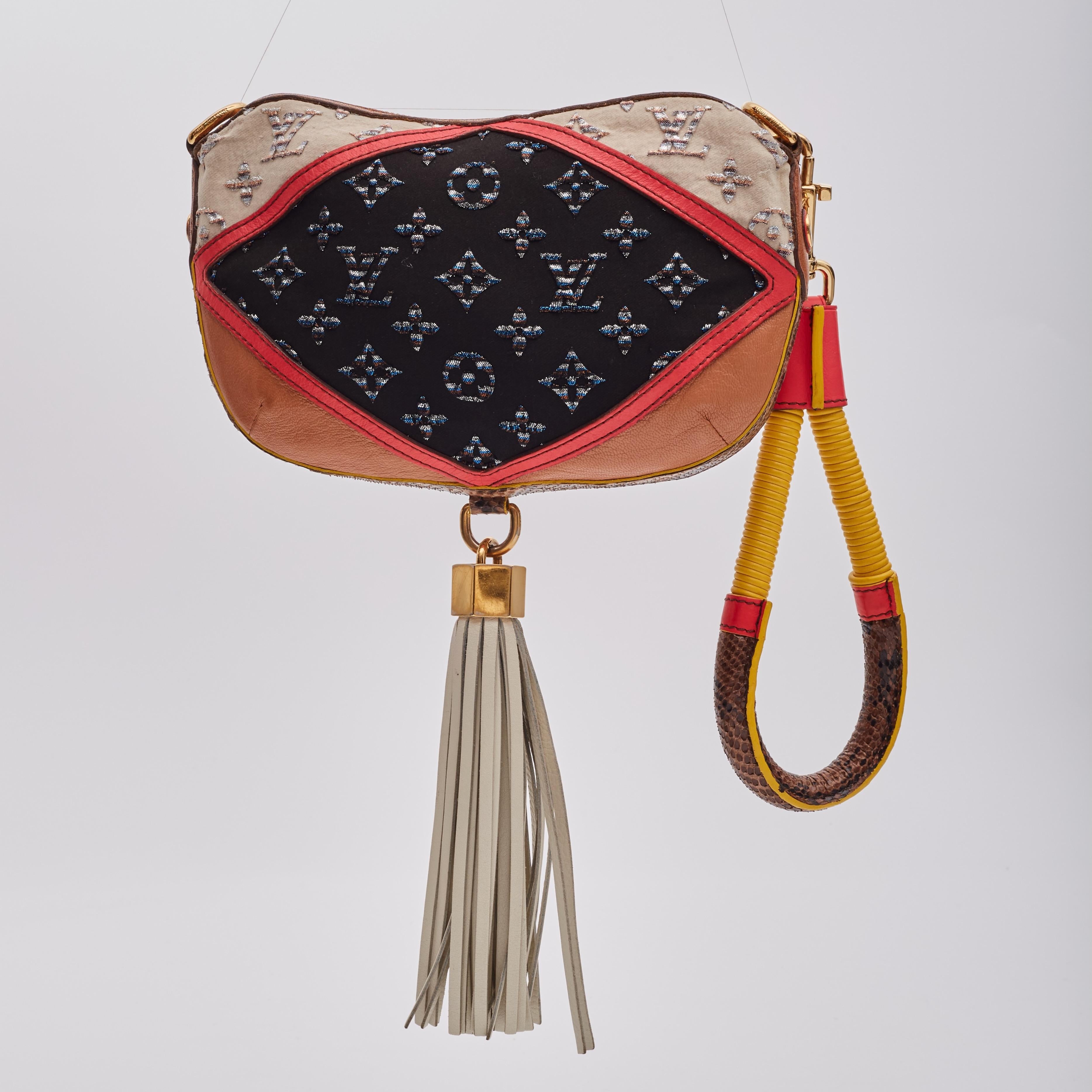 Cette pochette est réalisée en cuir tri-ton avec un monogramme Louis Vuitton pailleté et des embellissements en peau de python sur les côtés. Un bracelet très décoratif en python et en cuir rose avec un fermoir en or et un gland à franges en cuir