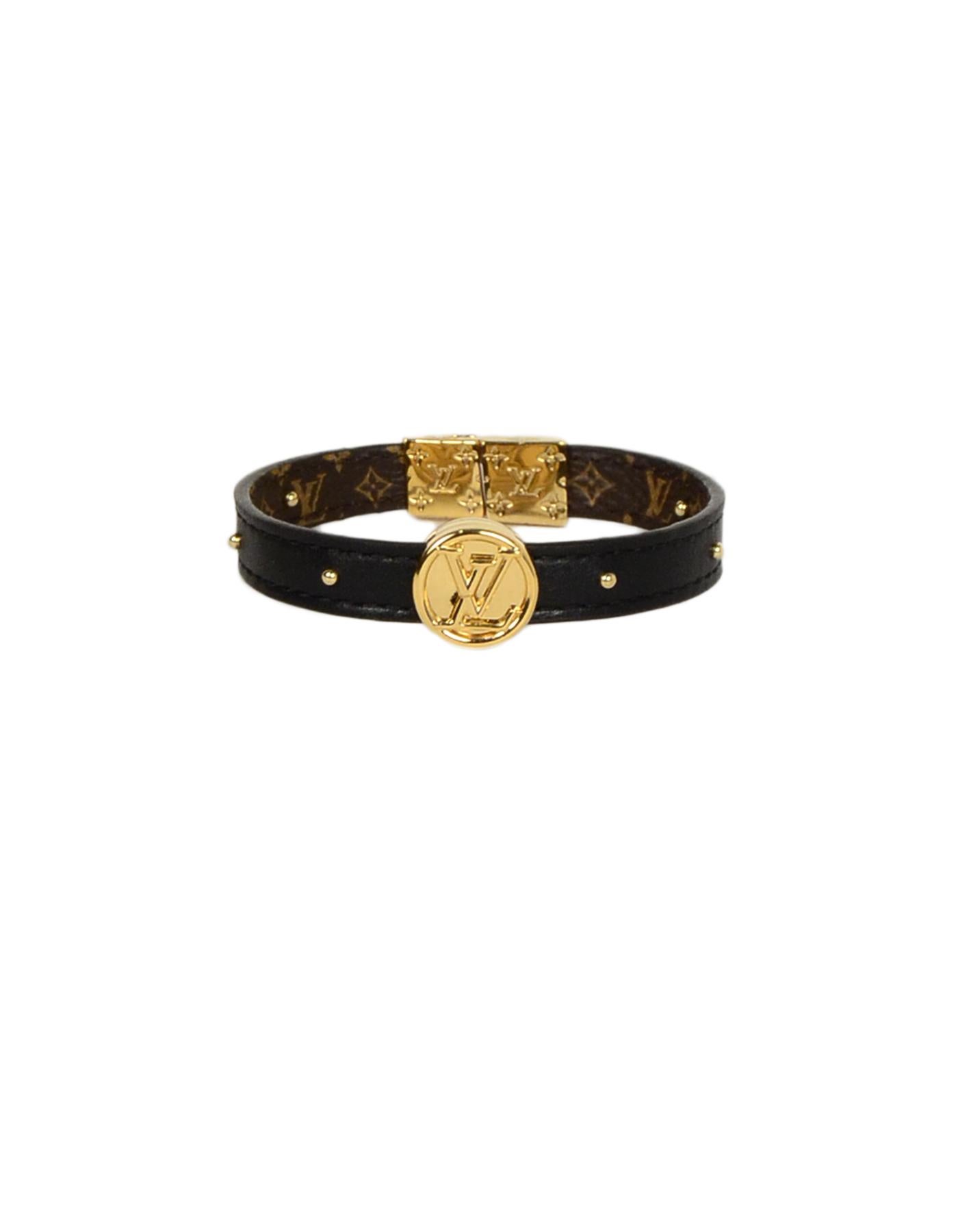 Louis Vuitton Monogram/Noir Black Circle Logo Reversible Studded Bracelet 
Made In: Spain
Color: Brown
Materials: Coated canvas, metal
Hallmarks: BC 0198
Closure/Opening: Clasp closure
Overall Condition: New
Estimated Retail: $515 + tax
Includes: