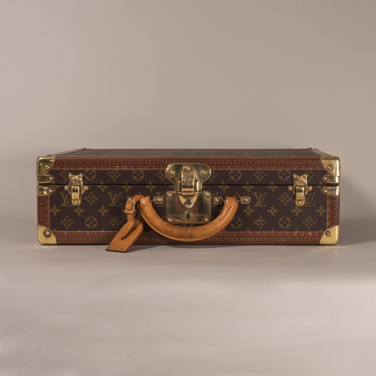 Louis Vuitton LV monogram suitcase with brass fittings, lozine trim and original lining that includes a pair of straps, circa 1980.

Dimensions: 50.5 cm/19⅞ inches (width) x 37 cm/14½ inches (depth) x 14.5 cm/5⅞ inches (height)

Louis Vuitton was