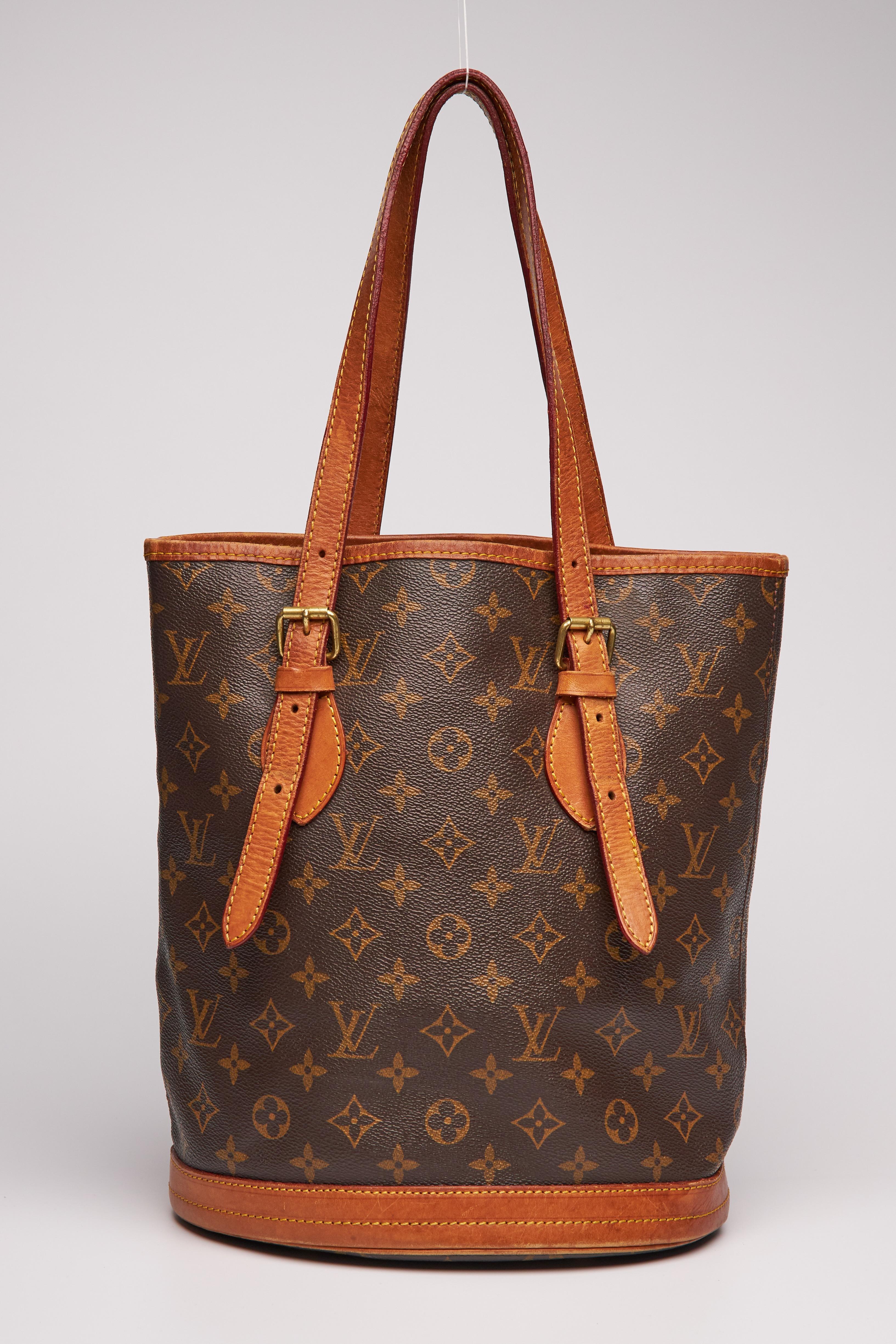 This bag measures 23 cm (10 inch) in height and is a Louis Vuitton classic that is finely crafted of traditional Louis Vuitton monogram print on coated canvas. The bag features natural vachetta leather including trim and tall dual strap handles as