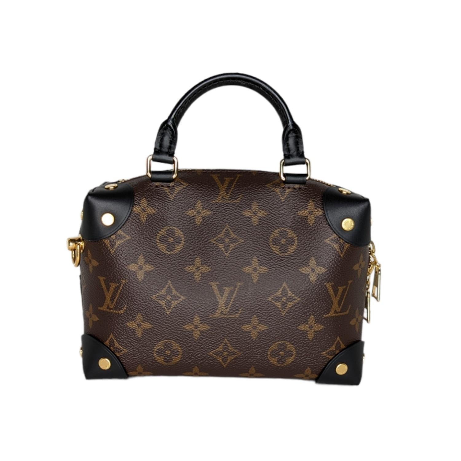 This stylish handbag is crafted of Louis Vuitton monogram toile canvas, with black leather corner details. The bag features a gold chain shoulder strap with polished brass hardware. The top zipper opens to a black microfiber interior with a zipper