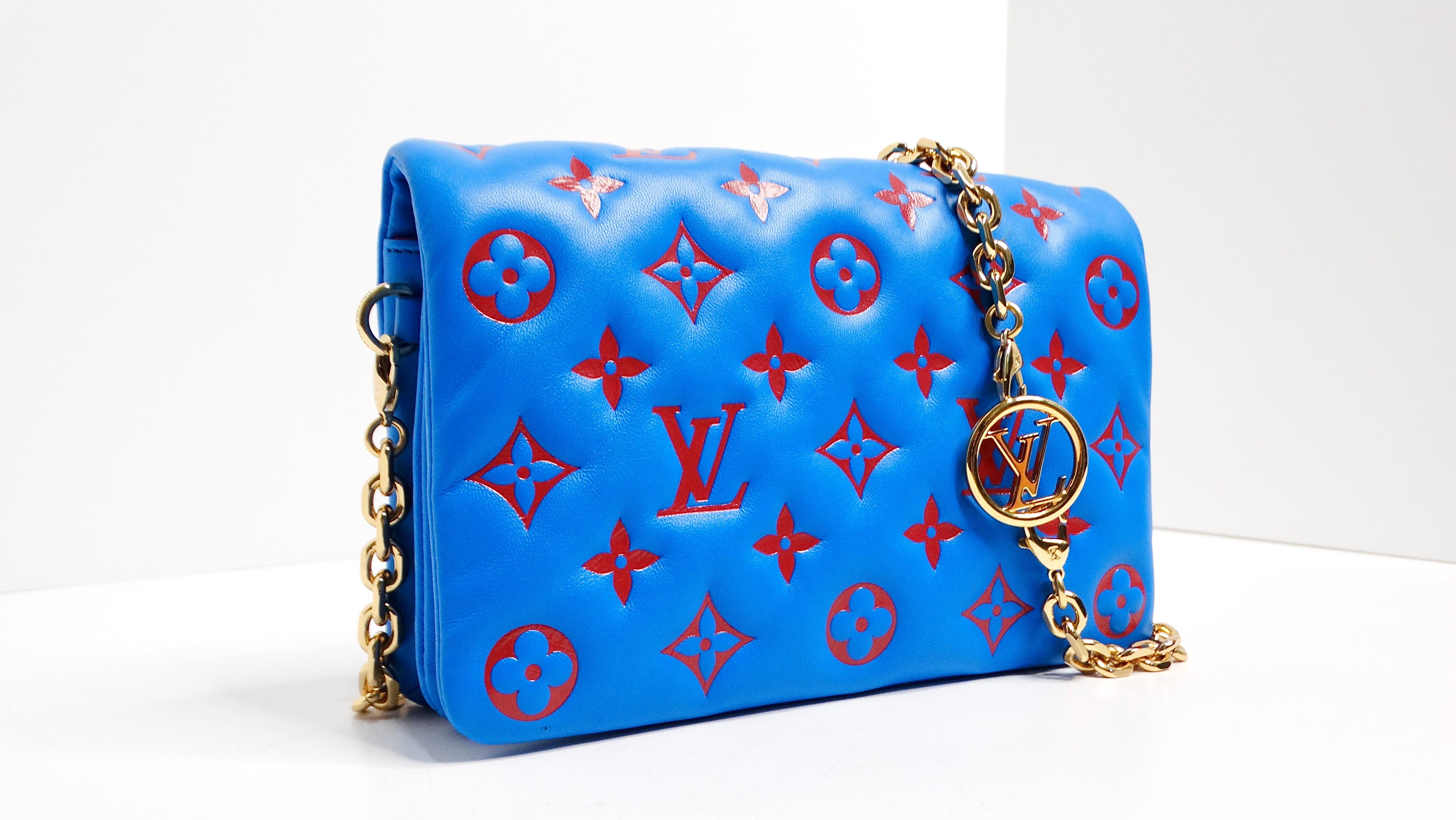 The Louis Vuitton Monogram Pochette Coussin Blue & Red Lambskin Bag is a stunning accessory that seamlessly blends vibrant color and luxurious craftsmanship. This exquisite piece, made in Italy, features a dynamic electric blue and red color palette