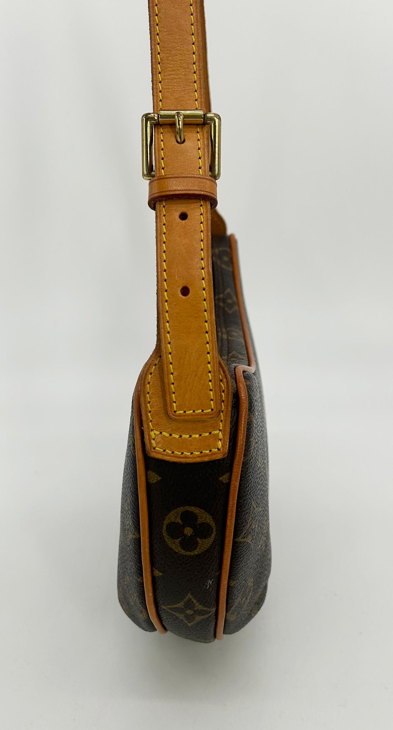 Louis Vuitton Monogram Pochette Croissant in excellent condition. Signature monogram canvas exterior in brown and tan LV print trimmed with tan leather piping and adjustable buckle handle/shoulder strap and sparkling golden brass hardware. Top