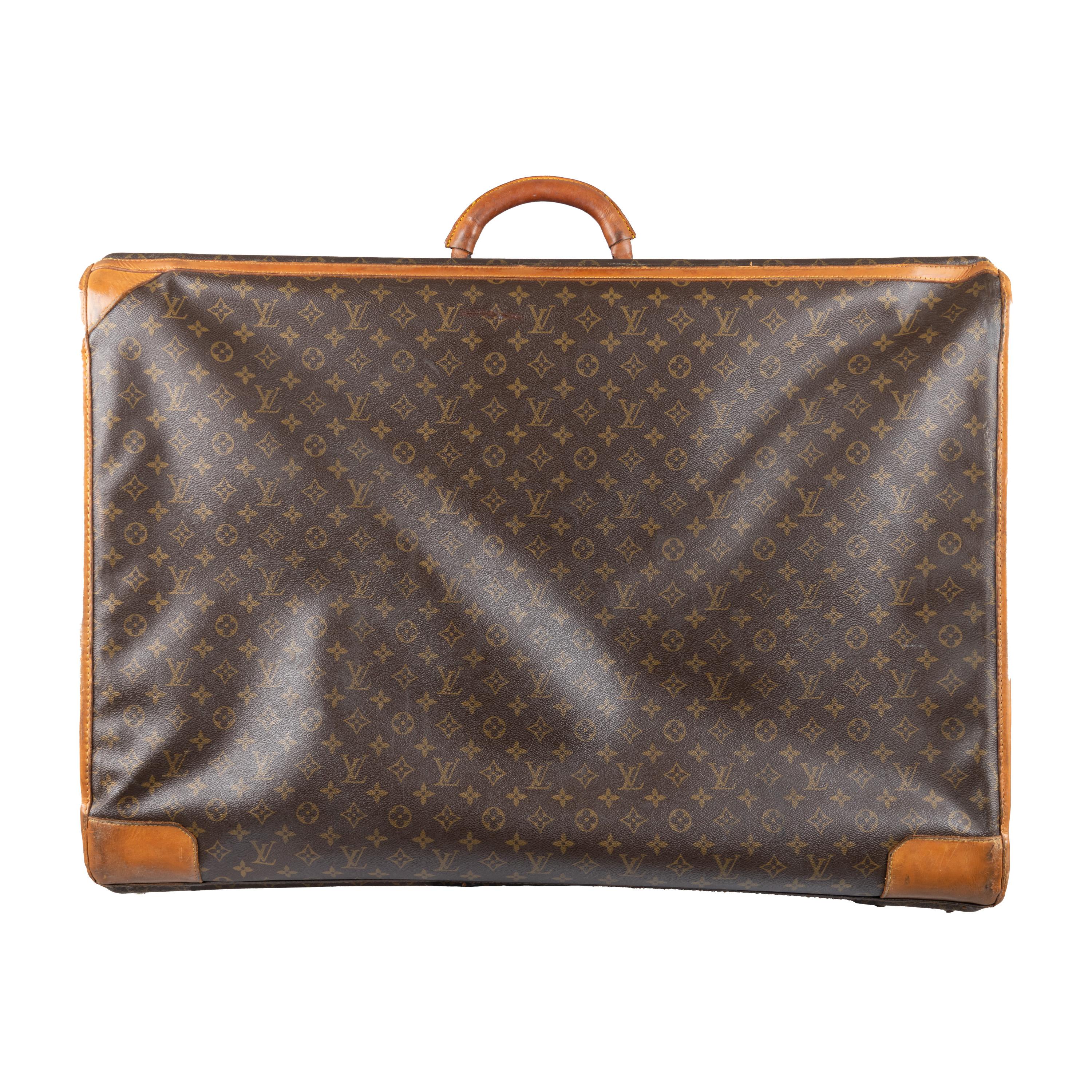 Crafted from Louis Vuitton's signature coated canvas, the bag features a leather-reinforced top handle and brass hardware with a numeral lock, plus a spacious interior with side pockets and straps. 

Remarks: There are many signs of wear.