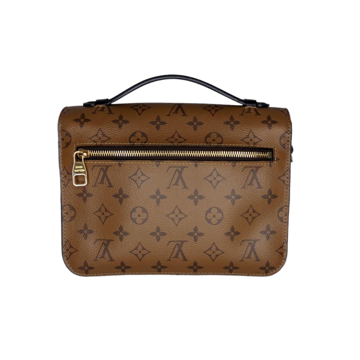 This handbag is crafted of Louis Vuitton monogram toile canvas in dark brown. The bag features a lighter brown canvas flap and back, a black leather strap handle, an optional adjustable light brown monogram canvas shoulder strap, a rear exterior