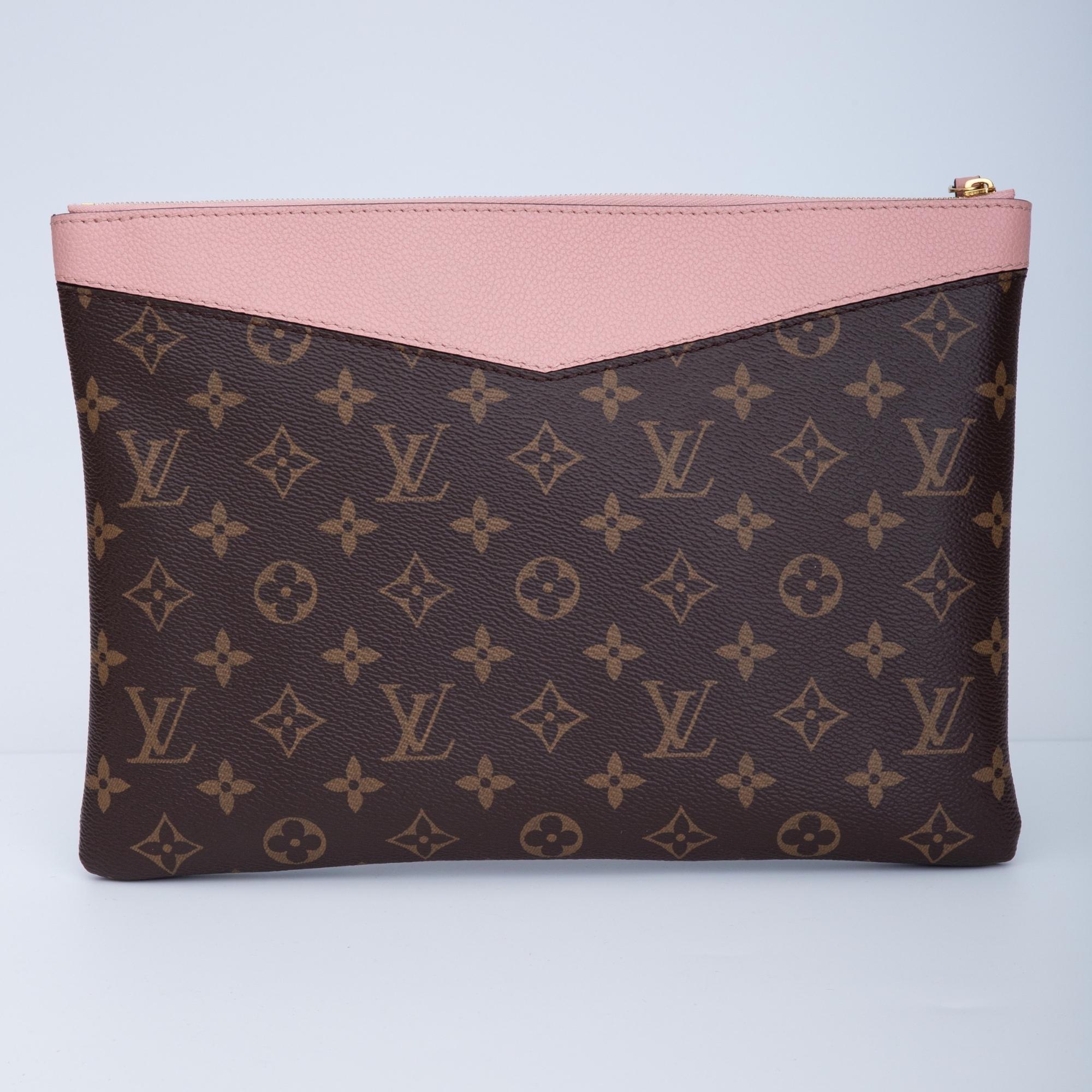 This pouch by Louis Vuitton is made with monogram canvas with subtly grained cowhide leather in rose poudre (pink). The bag can be carried on it’s own or slipped into a larger bag. The bag features top zip closure, matching pink microfiber lining. 1