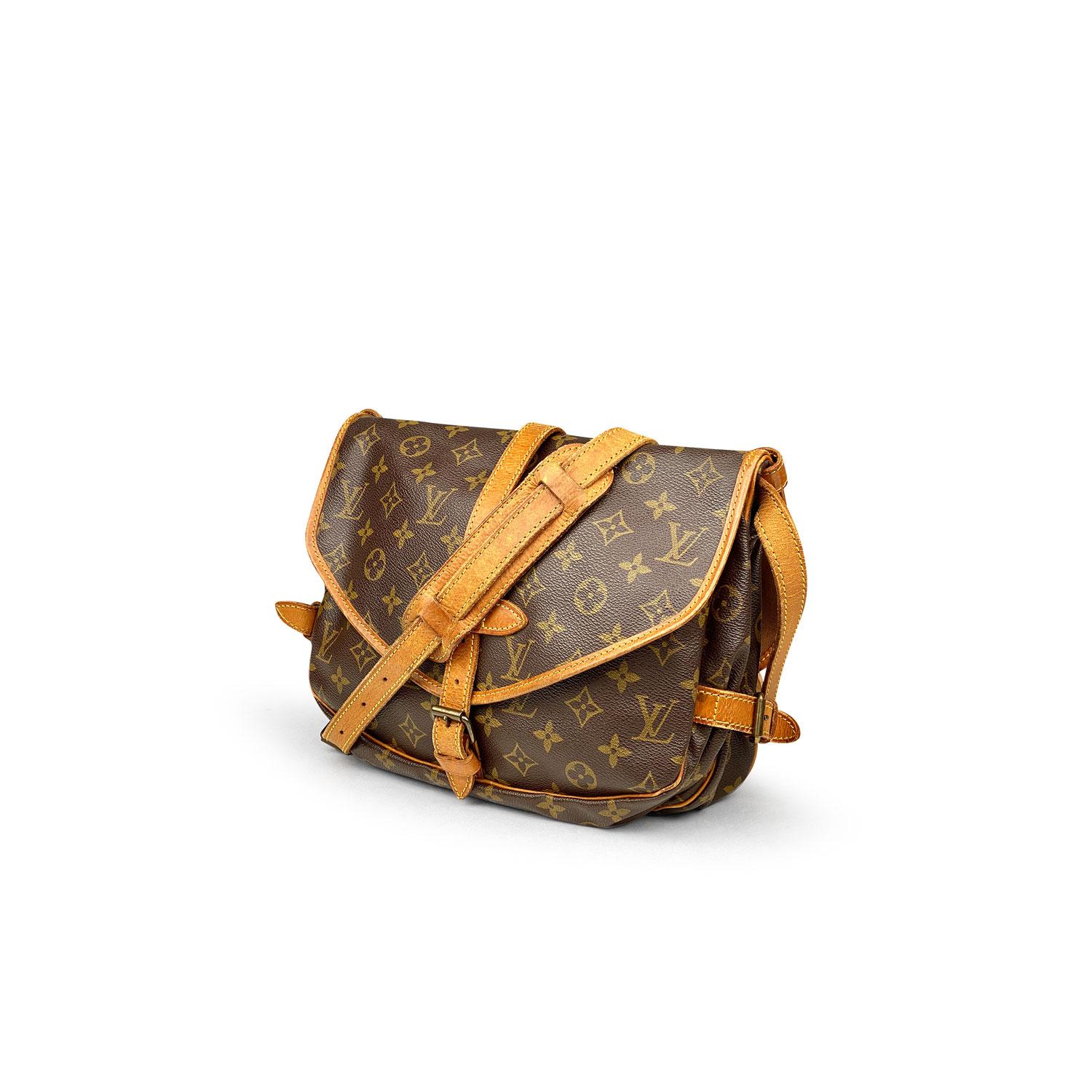 Brown and tan monogram coated canvas Louis Vuitton Saumur 30 with

- Brass hardware
- Tan vachetta trim
- Single flat shoulder strap featuring buckle adjustment
- Buckle expansions at sides
- Two compartments, tonal canvas lining, three slip pockets