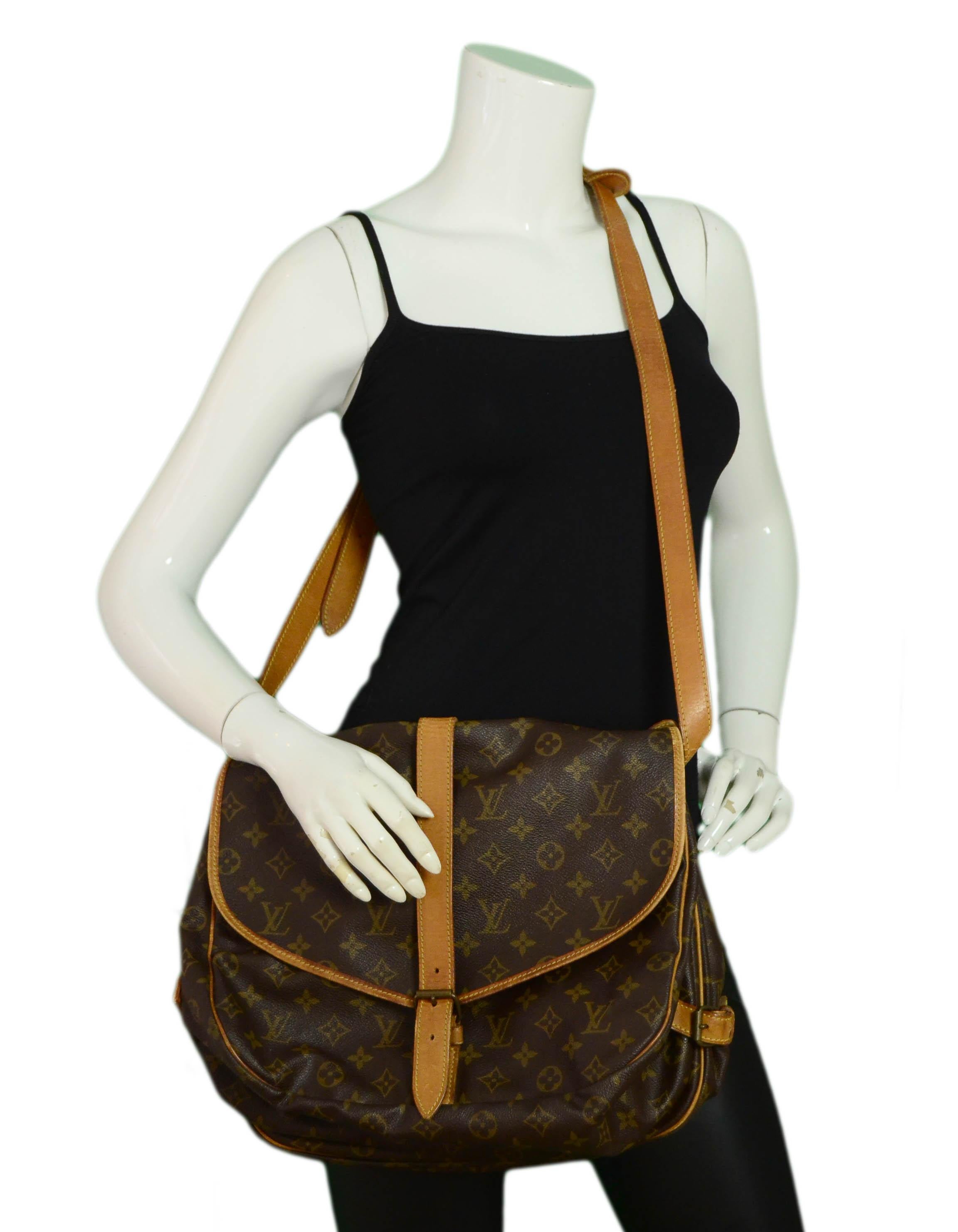 Louis Vuitton Monogram Saumur 35 Double Saddle Messenger Bag

Made In: France
Year of Production: 1990
Color: Brown coated canvas
Hardware: Goldtone
Materials: Coated canvas and vachetta leather
Lining: Canvas
Closure/Opening: Flapover w/buckle