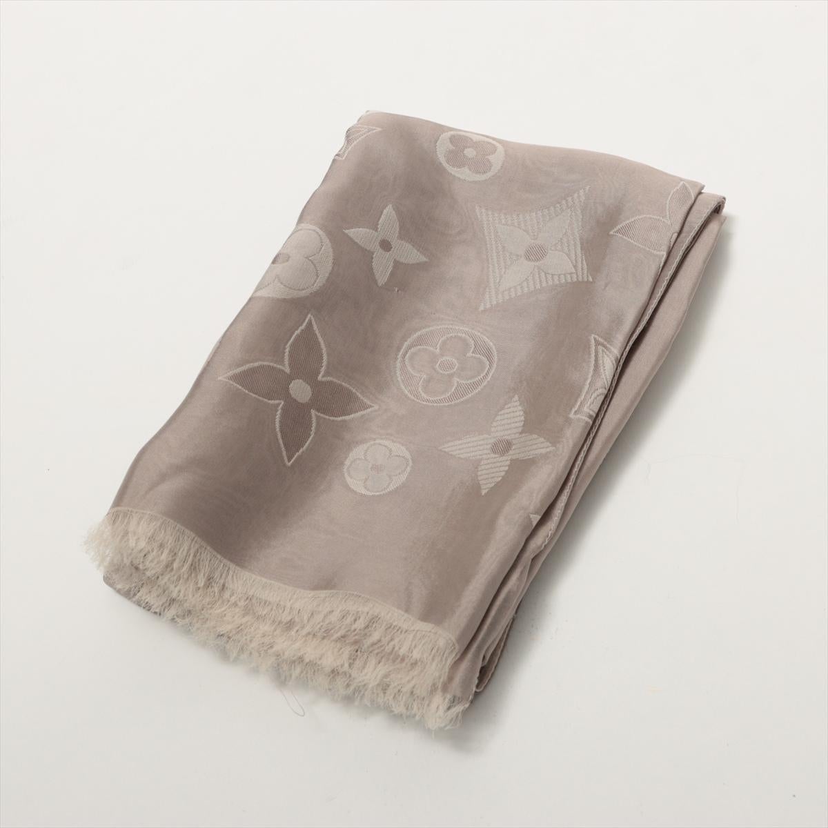 The Louis Vuitton Monogram Shawl in Greige seamlessly combines luxury and versatility. Made from a blend of viscose and silk, it offers a sumptuously soft feel against the skin while exuding an air of refined elegance. The iconic LV monogram