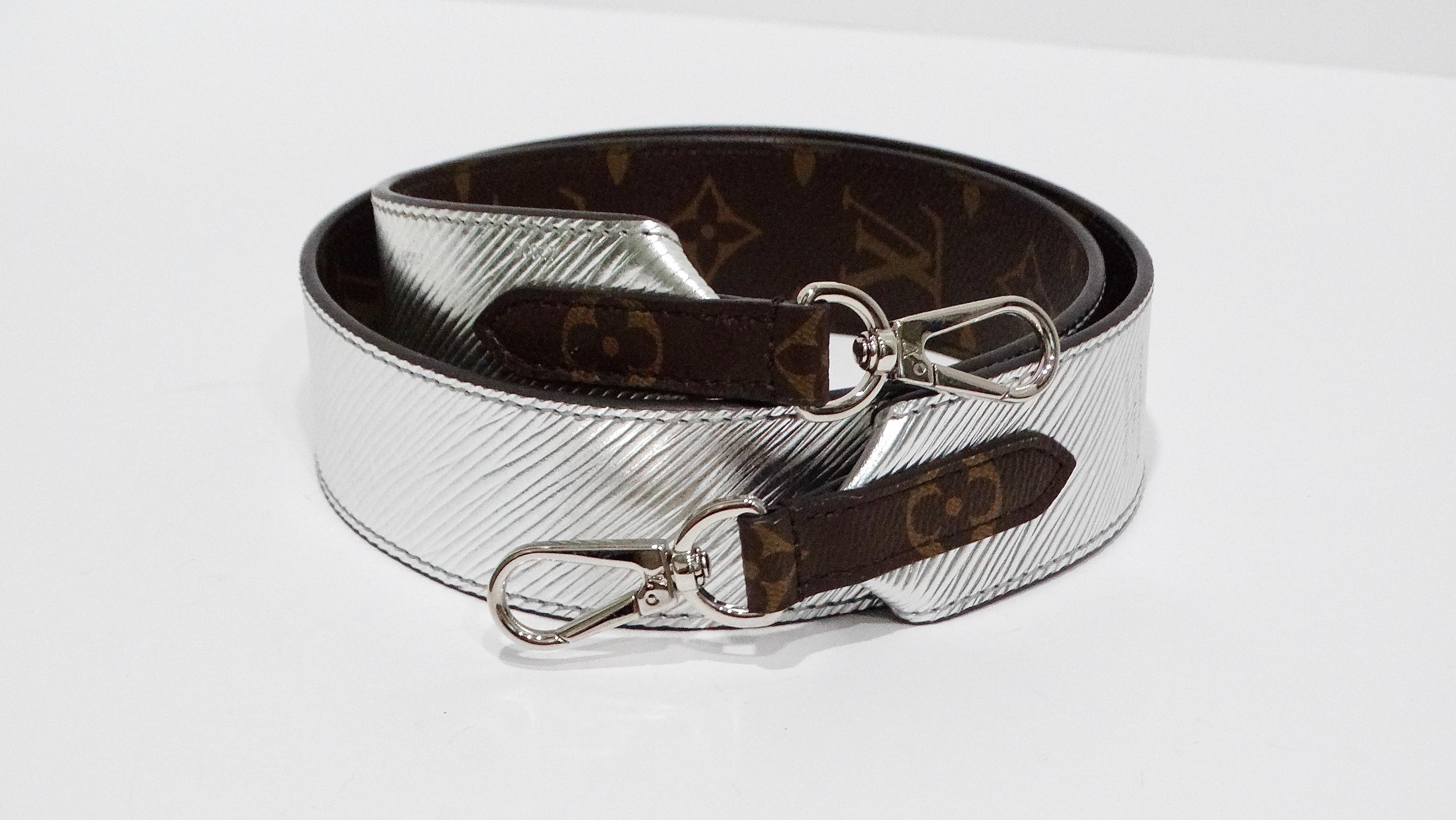 The Louis Vuitton leather monogram and metallic silver reversible shoulder strap is a sleek and versatile accessory designed to elevate any outfit. This wide, stylish strap features the classic LV monogram on one side and a striking metallic silver