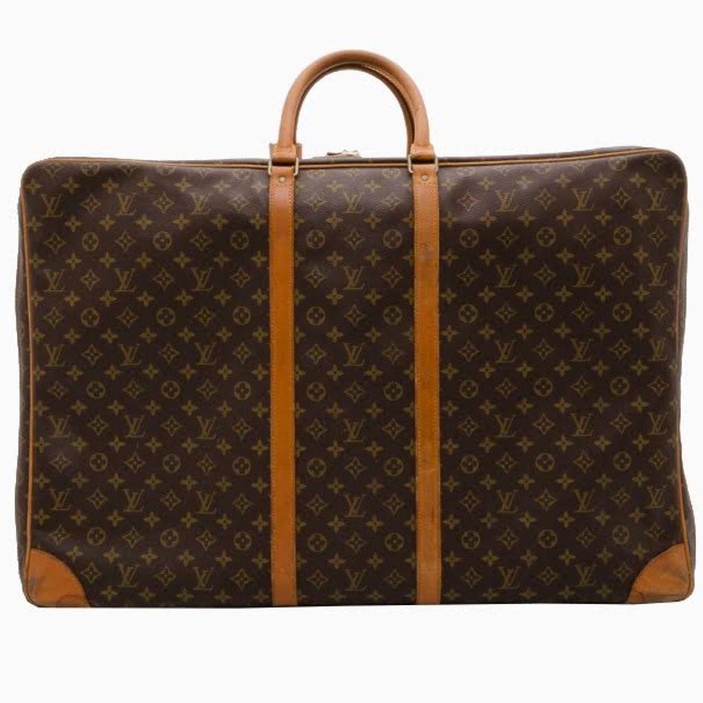 Enjoy packing a little more with this fashionable and considerably large monogram Sirius 70 travel bag from Louis Vuitton. Crafted from monogram coated canvas with tan leather trim, the exterior features a functional double zipper and rolled leather