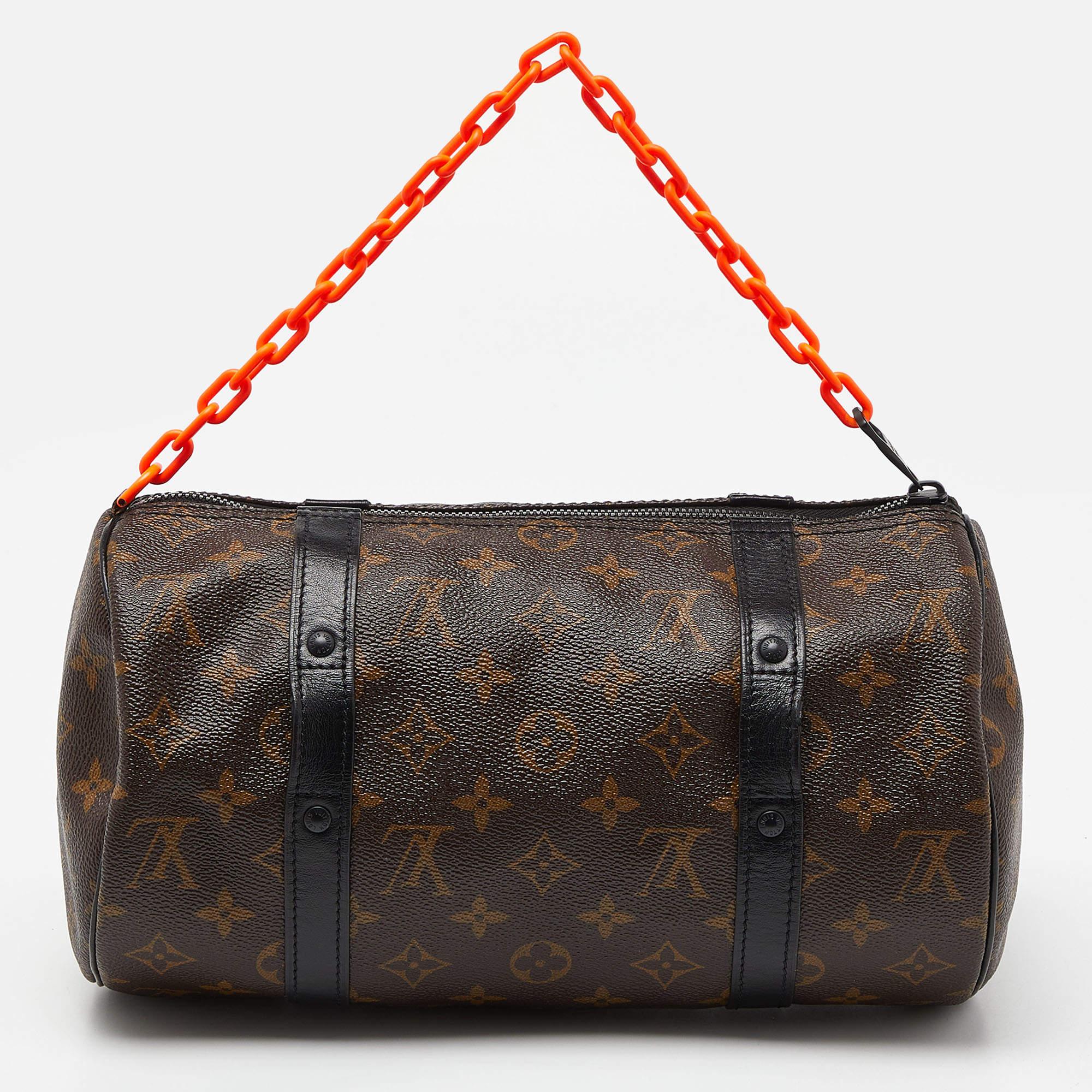 The Louis Vuitton Papillon Bag is a luxurious and iconic accessory featuring the brand's signature monogram canvas adorned with an orange chain-link strap. This compact handbag showcases a classic rounded silhouette, black-tone hardware, and a