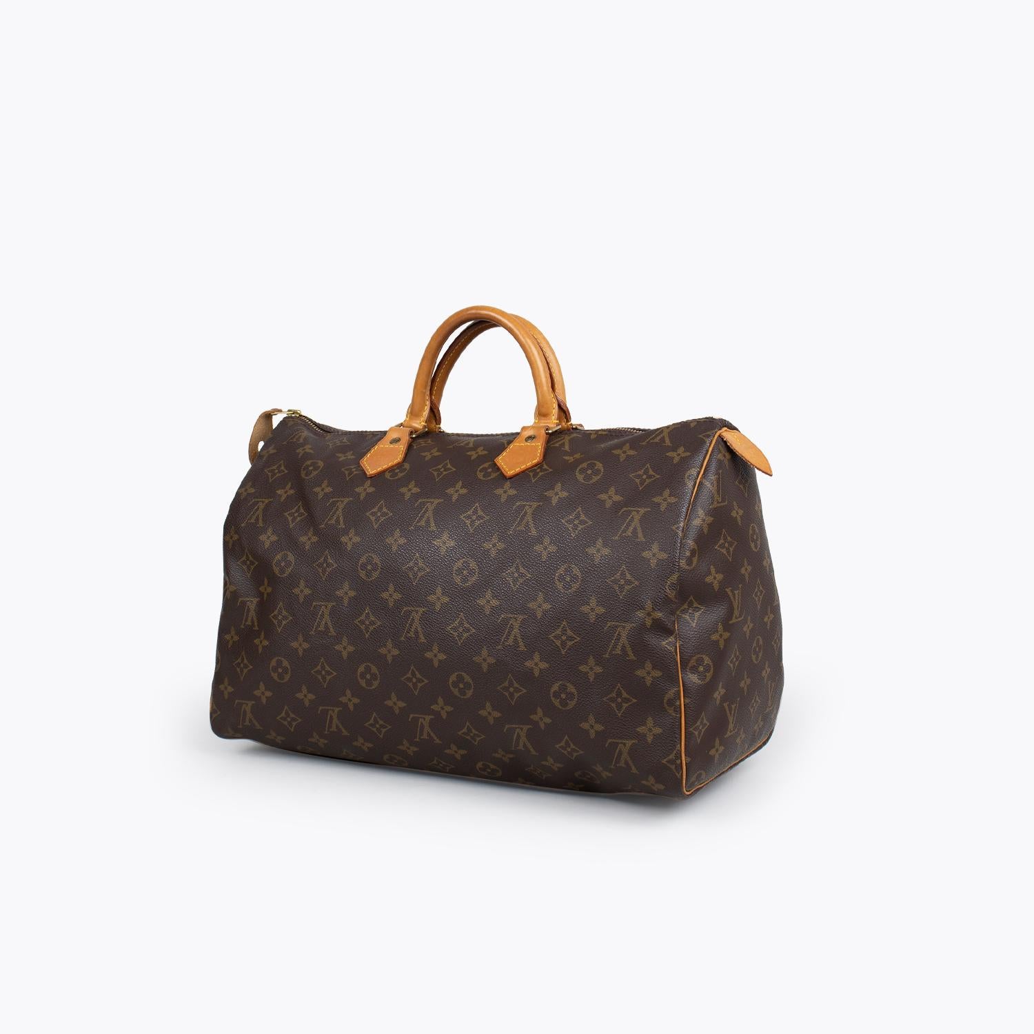 Brown and tan monogram coated canvas Louis Vuitton Speedy 40 with

- Brass hardware
- Tan vachetta trim
- Dual rolled top handles
- Brown canvas interior
- Single interior slit pocket and zip closure at top

Overall Preloved Condition: Very