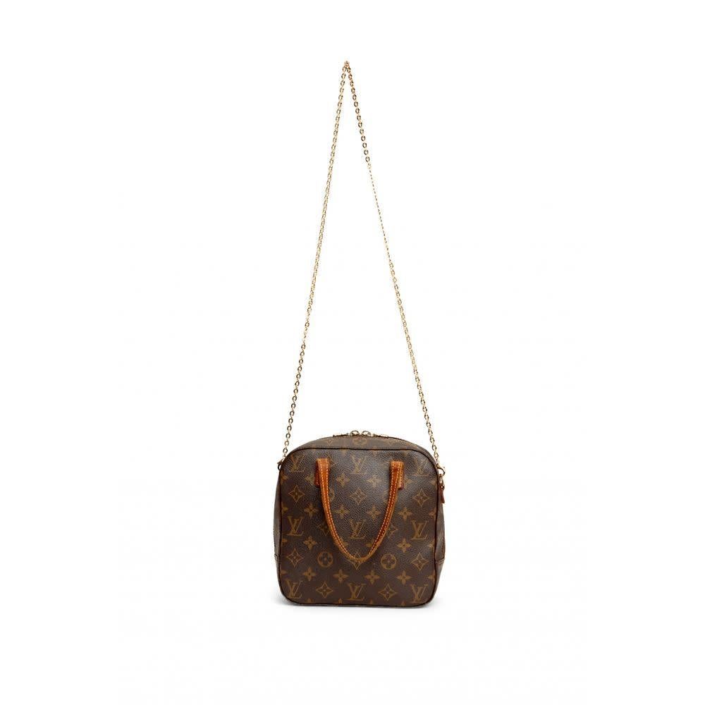 This style is made of brown monogram canvas and features, long dual natural cowhide leather flat top handles, zip around closure, brass hardware and ivory interior lining. 

COLOR: Brown
MATERIAL: Coated canvas
DATE CODE: AR0095
MEASURES: H 8” x L