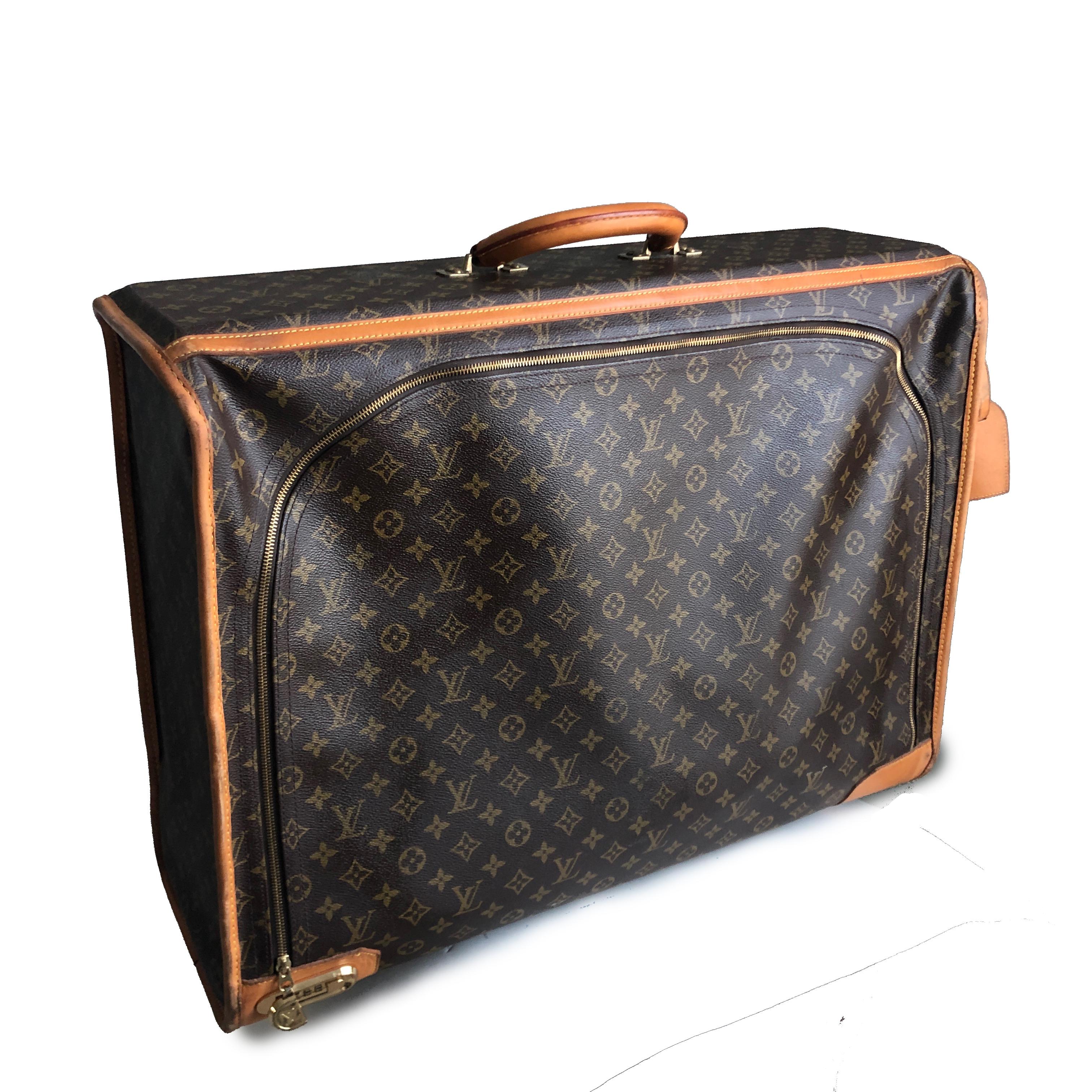 Travel in style with vintage Louis Vuitton luggage!  Made around the 80s, this large monogram canvas suitcase is trimmed in vachetta leather and features a built-in combination lock and leather ID Tag.  It's lined in brown fabric with two removable,