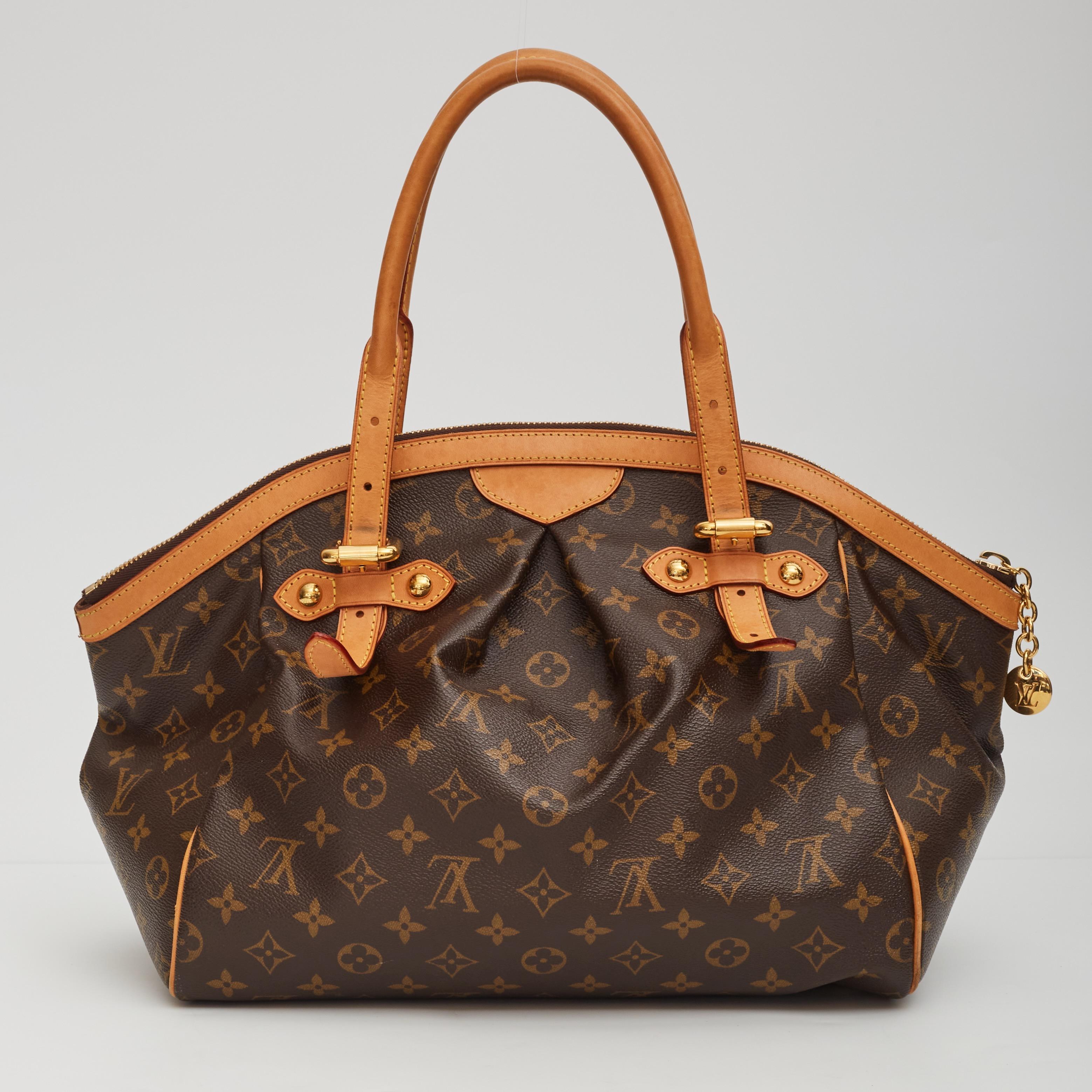 This luxurious Tivoli tote in the largest size is constructed of pleated Louis Vuitton monogram on toile canvas. The bag features signature natural vachetta leather trim including dual tall rolled top handles, and polished brass hardware including