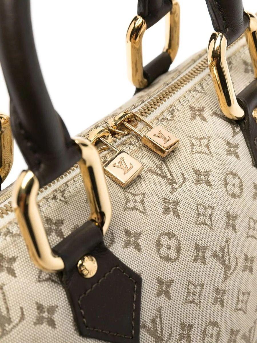 This unique version of a Louis Vuitton tote features several twists on a classic top-handle tote bag. Its elegantly elongated silhouette is crafted in beige-toned monogrammed canvas, accented by thick gold-tone hardware and a contrast brown leather
