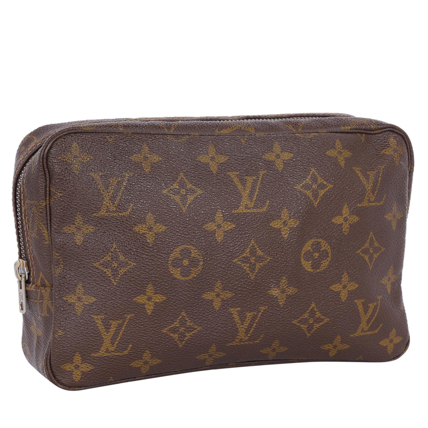Authentic, pre loved Louis Vuitton Trousse 23 toilette unisex brown monogram canvas cosmetic bag. Features LV's traditional monogram canvas with piping and gold-tone hardware. The interior features washable lining with one slit pocket and three