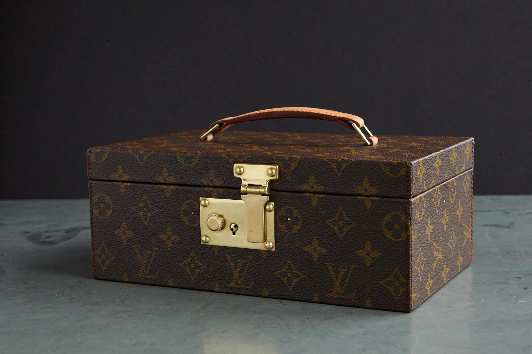 Exceptional 1970s Louis Vuitton monogrammed canvas vanity or cosmetic travel case with stitched leather top handle, brass hardware and flip lock closure with two keys. The inside is lined with contrasting leather and features a fabric lined