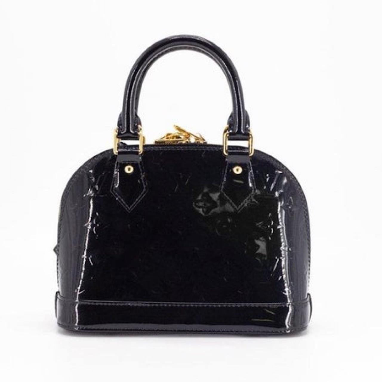 Vernis mens varnish auf Französisch, was die Oberfläche der Tasche perfekt beschreibt. Die Tasche ist aus Vernix-Leder mit Monogramm-Prägung gefertigt und verfügt über einen Reißverschluss an der Oberseite und zwei gerollte Ledergriffe.  

FARBE: