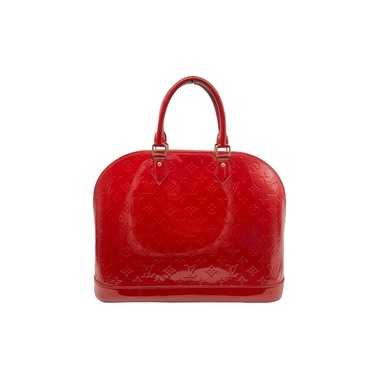 This Louis Vuitton Alma GM was made in the U.S.A. in 2013 and it is crafted of Louis Vuitton's red Monogram Vernis patent leather exterior with gold-tone hardware features. It has rolled leather top handles it features a gold-tone zipper top closure