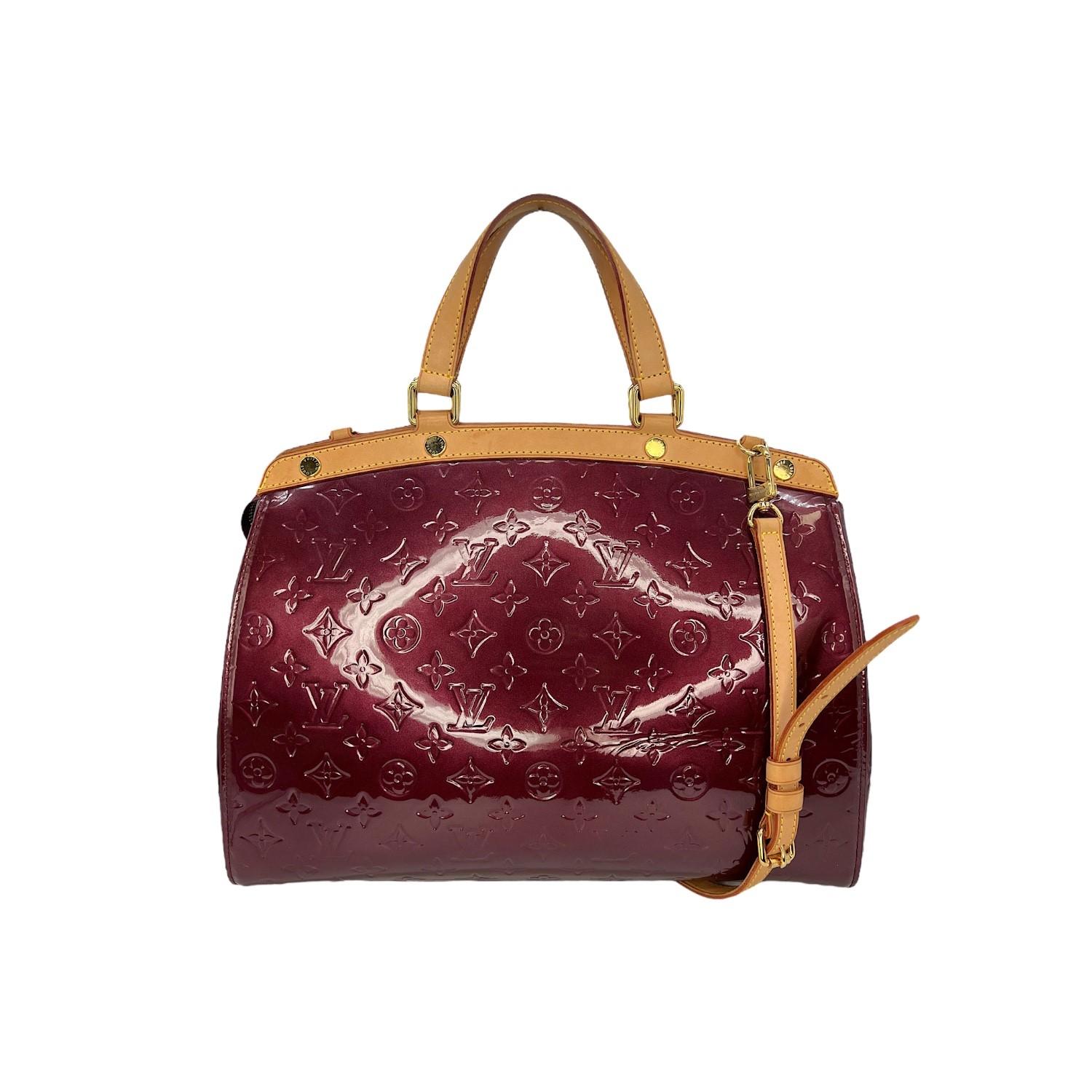 This Louis Vuitton Monogram Brea GM was made in France and exquisitely crafted of a burgundy-colored Louis Vuitton Monogram Vernis patent leather exterior with leather trimming and gold-tone hardware features. It has a zipper closure that opens to a