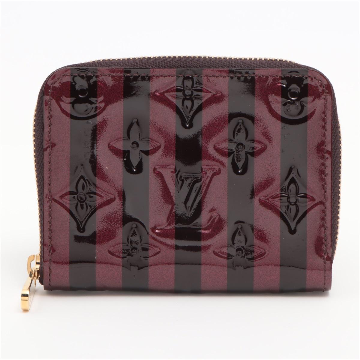 The Louis Vuitton Monogram Vernis Stripe Zippy Coin Purse in Amarante is an elegant and compact accessory that exudes modern sophistication. Crafted from the iconic Vernis patent leather, the wallet features a refined stripe pattern in the deep