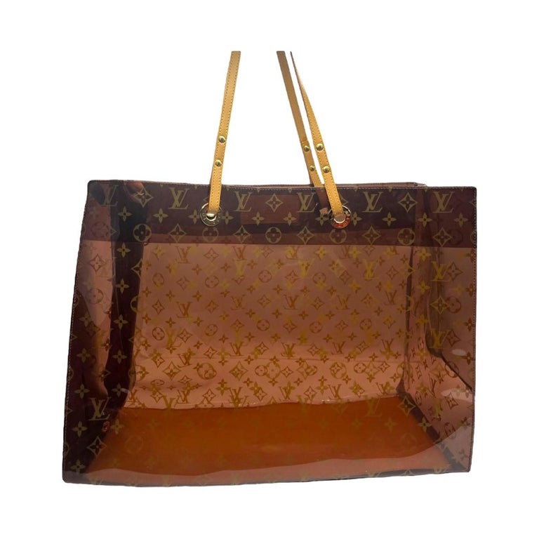 We are offering this timeless Louis Vuitton Monogram GM Tote. Designed in 2000 by Marc Jacobs, this bag was made in Spain and was crafted with a transparent LV monogram vinyl material with luxurious vachetta leather handles and brass hardware. The