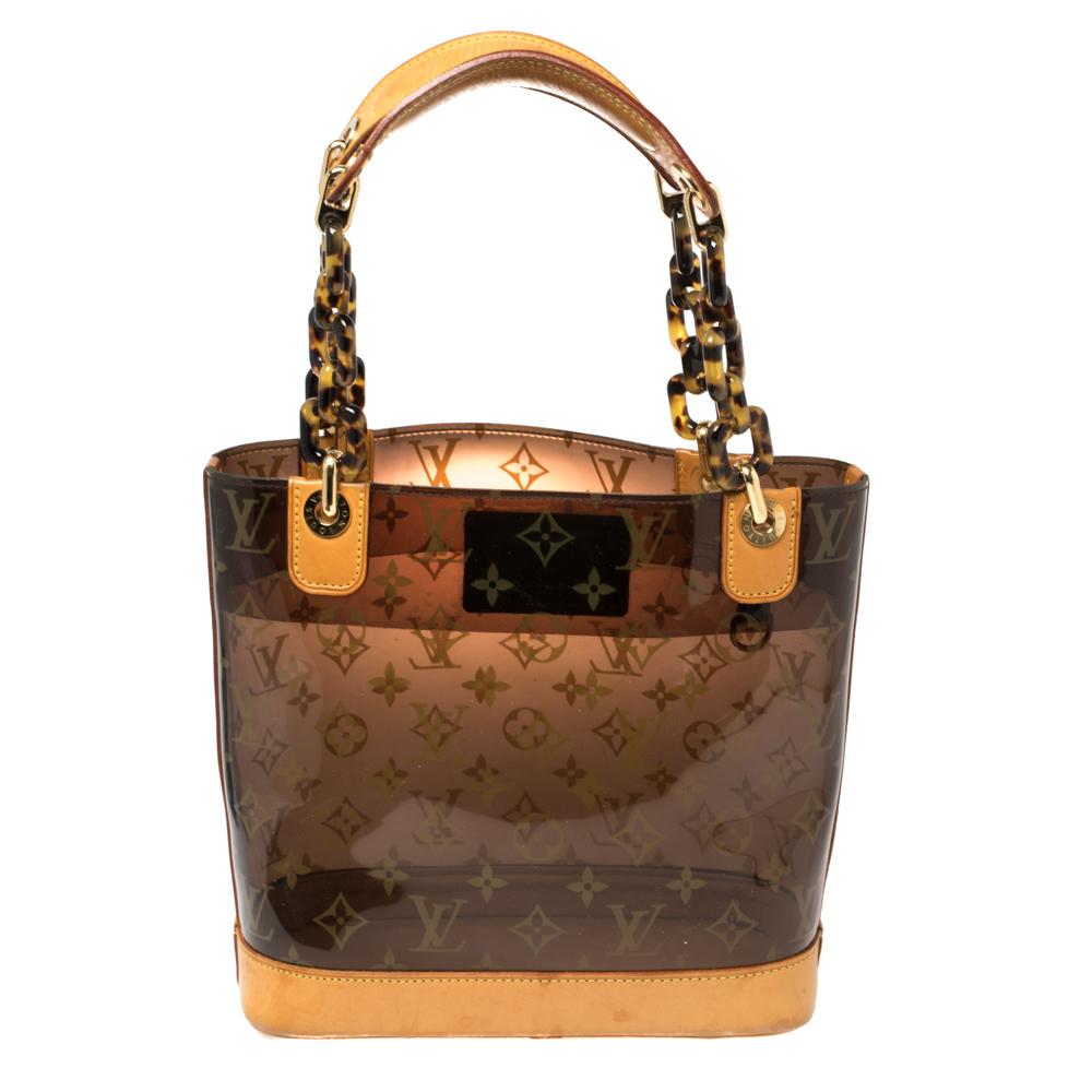 Louis Vuitton is known for its excellence in making and this handbag is no different. This exquisite Ambre bag is a limited edition bag. Crafted to perfection from monogram vinyl, it features gold-tone chain and leather double handles. An open-top