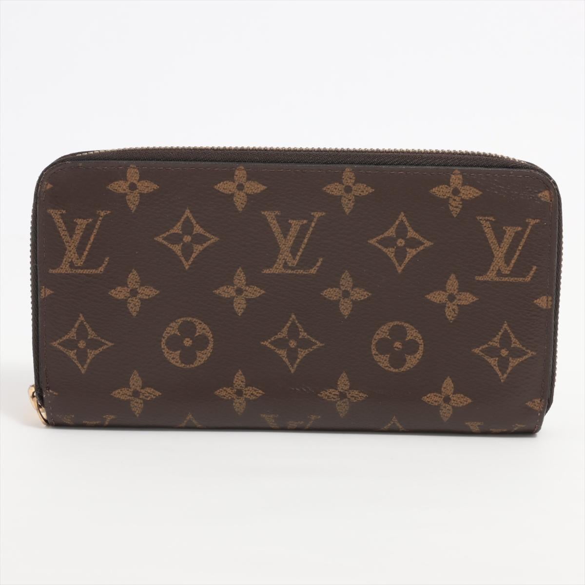 The Louis Vuitton Monogram Zippy Wallet in Coquelicot is a vibrant and sophisticated accessory that seamlessly blends the iconic Monogram canvas with a bold red hue. The wallet showcases the instantly recognizable LV monogram pattern, a symbol of