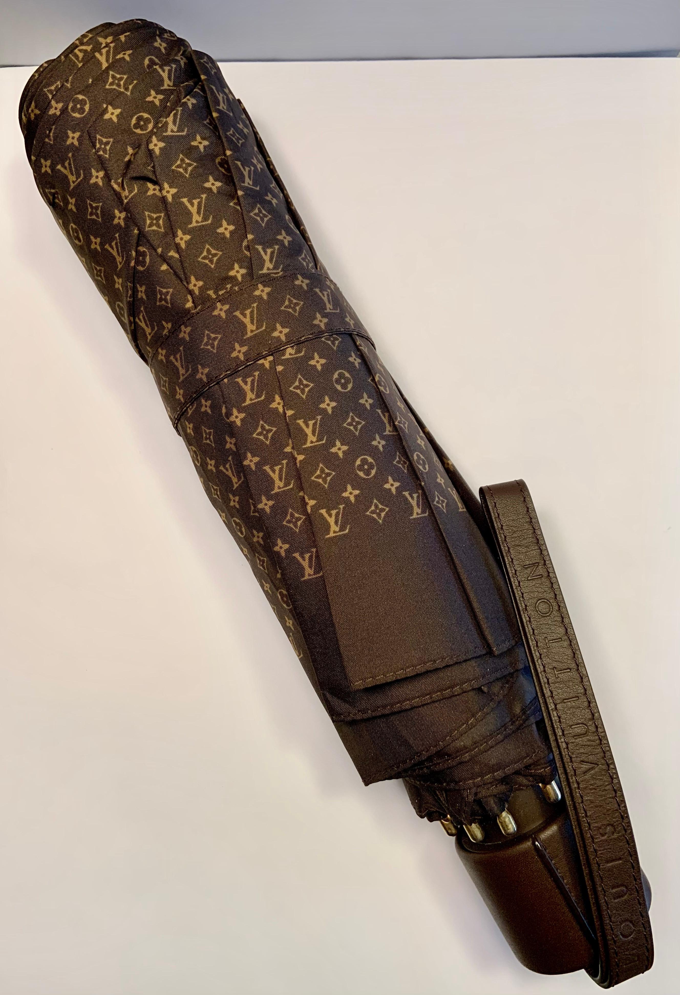 Stay dry in style with this chic brown and tan monogrammed nylon Louis Vuitton collapsible umbrella. It has a moka leather strap and handle, and a matching nylon cover.  It is in excellent condition and appears unused.
Measurements;  Open  Height