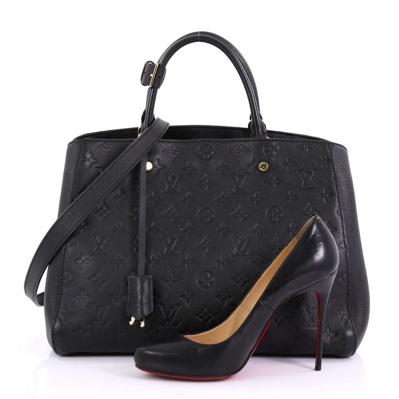 This Louis Vuitton Montaigne Handbag Monogram Empreinte Leather GM, crafted in Black monogram empreinte leather, features dual rolled leather handles and gold-tone hardware. Its hook closure opens to a gray fabric interior with middle zip