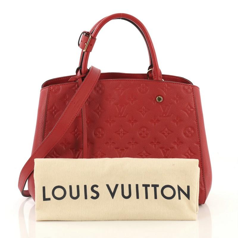 This Louis Vuitton Montaigne Handbag Monogram Empreinte Leather MM, crafted in red monogram empreinte leather, features dual rolled leather handles, protective base studs, and gold-tone hardware. Its hook closure opens to a red fabric interior with