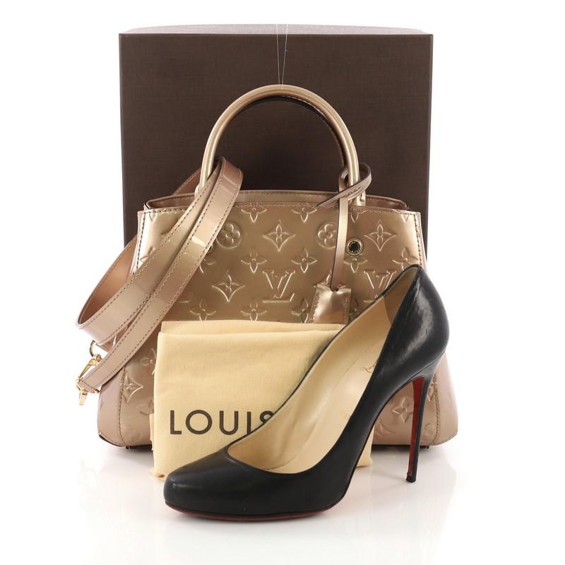 This Louis Vuitton Montaigne Handbag Monogram Vernis BB, crafted from bronze monogram vernis leather, features dual rolled handles and gold-tone hardware. Its hook closure opens to a brown fabric interior divided into two compartments with middle