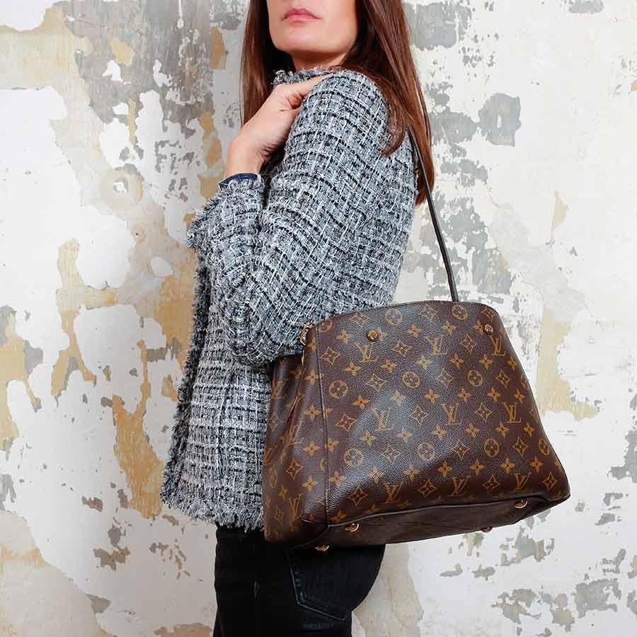 LOUIS VUITTON bag, Montaigne Collection, in brown monogram canvas. The inside of the bag is in burgundy suede with two large storage compartments separated by a zipped pocket. In the first compartment there is a flat pocket and in the second two
