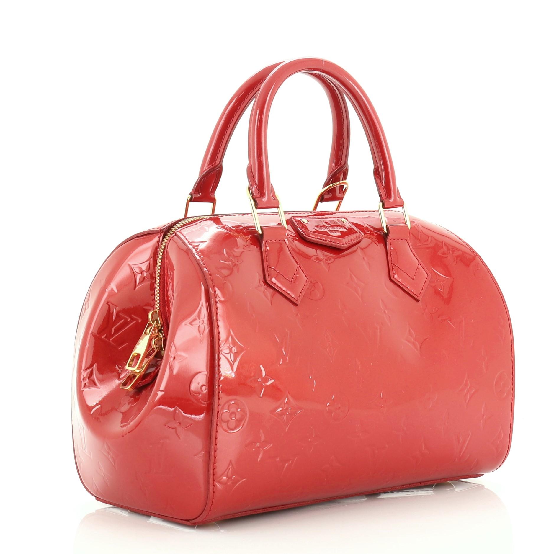 This Louis Vuitton Montana Handbag Monogram Vernis, crafted in red monogram vernis leather, features dual rolled handles, protective base studs and gold-tone hardware. Its zip closure opens to a red fabric interior with slip pocket. Authenticity