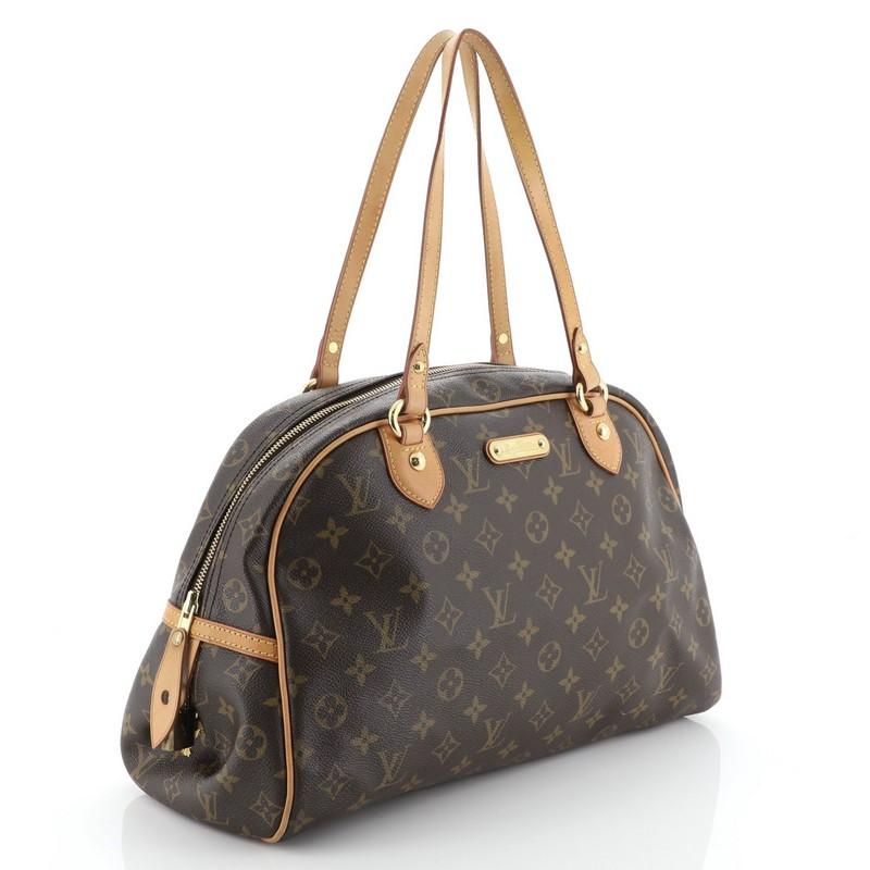 This Louis Vuitton Montorgueil Handbag Monogram Canvas GM, crafted in brown monogram coated canvas, features tall dual flat vachetta leather handles and trim and gold-tone hardware. Its top zip closure opens to a brown fabric interior. Authenticity