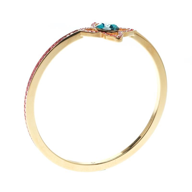 This bangle bracelet from Louis Vuitton is characterised by sparkly colours. First, the bangle was sculpted out of gold-tone metal in a simple band with a monogram flower as the centerpiece. Then, colourful crystals were applied by hand around it,