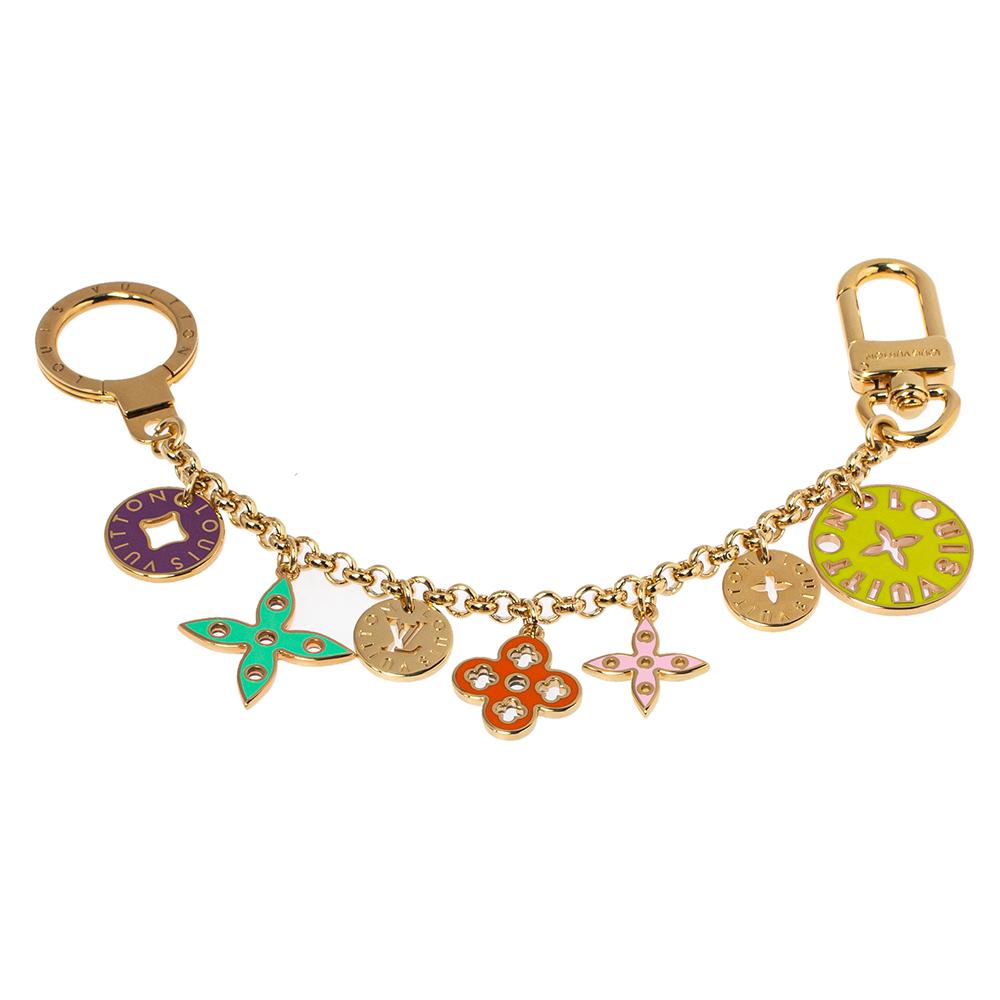 Let your pretty bag enjoy the company of this lovely Fleur de Monogram bag charm by Louis Vuitton. Made from gold-tone metal, the chain holds signature motifs enhanced with colorful enamel. Eye-catching and easy to attach, this bag will make a fine