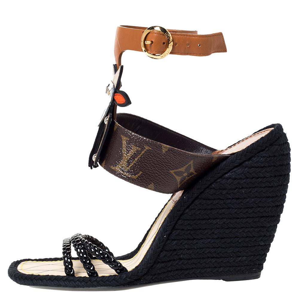 Featuring a quirky design, this flat pair of sandals from Louis Vuitton has the LV monogram on the straps near the ankles and mixed materials come together to form a tribal mask embellishment on it. Woven straps at the front, ankle straps with a