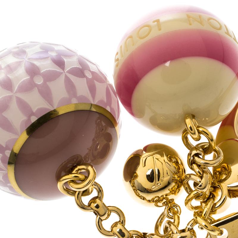 Add a fresh dose of style to your everyday bag with this playful accessory. This Mini Lin Croisette bag charm from Louis Vuitton features two multicoloured round pearl-like motifs adorned with signature details that playfully rests on a gold-tone