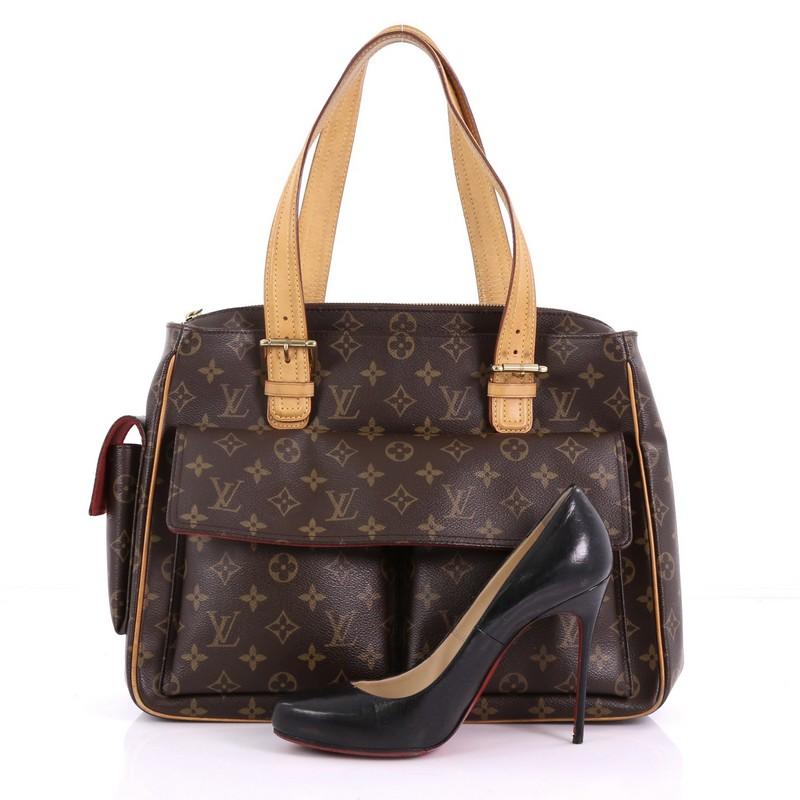 This Louis Vuitton Multipli Cite Handbag Monogram Canvas, crafted from brown monogram printed canvas, features dual flat vachetta leather straps with buckle details, two exterior front flap pockets, a single exterior side flap pocket, and gold-tone
