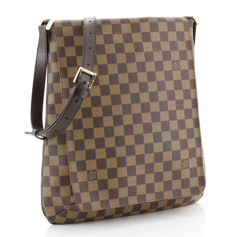 This Louis Vuitton Musette Handbag Damier GM, crafted from damier ebene coated canvas, features a full flap, adjustable dark brown leather strap, and gold-tone hardware. Its magnetic snap closure opens to a brown microfiber interior with side slip