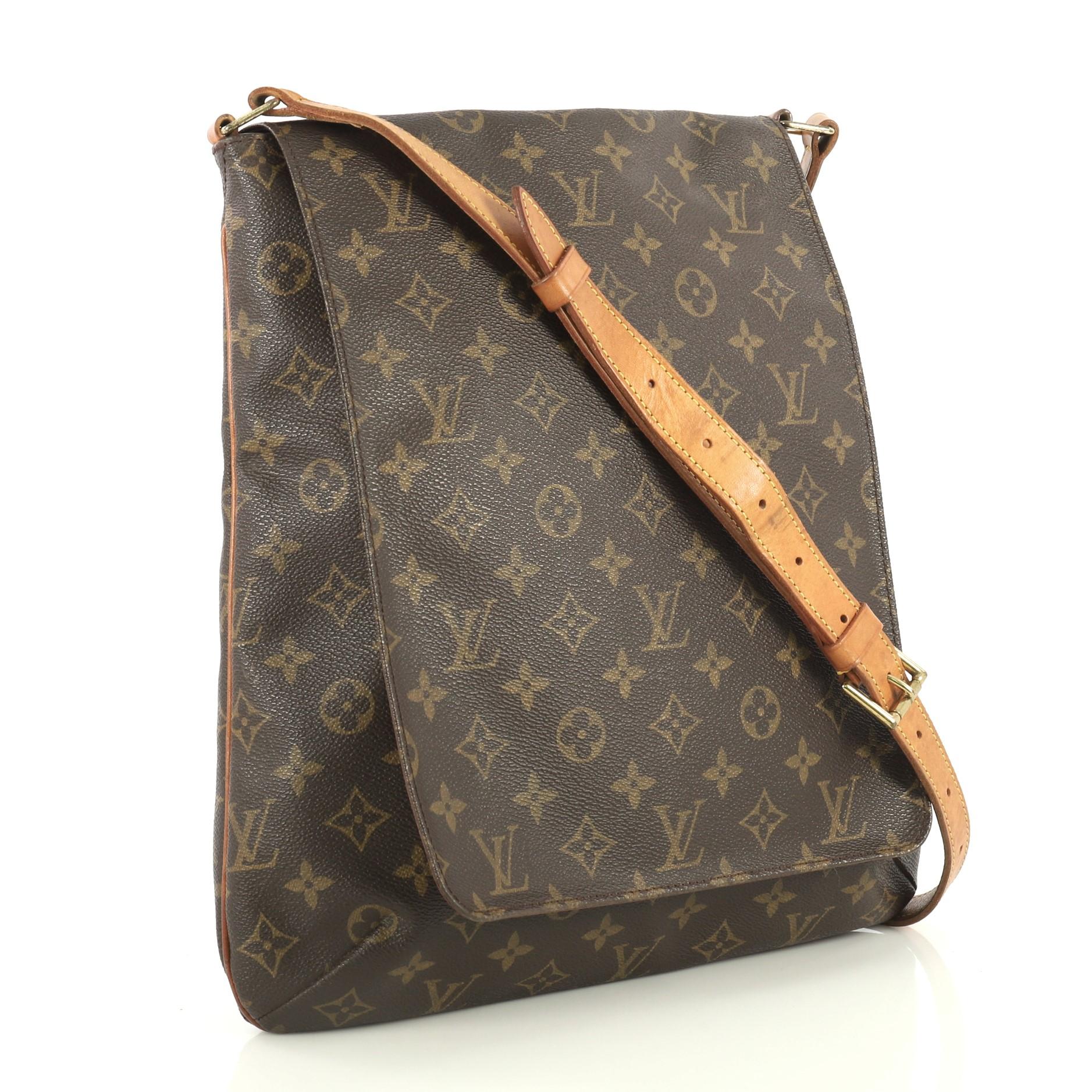 This Louis Vuitton Musette Salsa Handbag Monogram Canvas GM, crafted from brown monogram coated canvas, features adjustable cowhide leather strap, full frontal flap, and gold-tone hardware. Its hidden snap closure opens to a brown microfiber