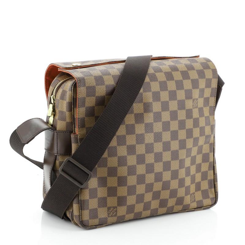 This Louis Vuitton Naviglio Handbag Damier, crafted in damier ebene coated canvas, features an adjustable canvas strap, dual flap design, and gold-tone hardware. Its flap and zip closure opens to an orange fabric interior with slip pocket.